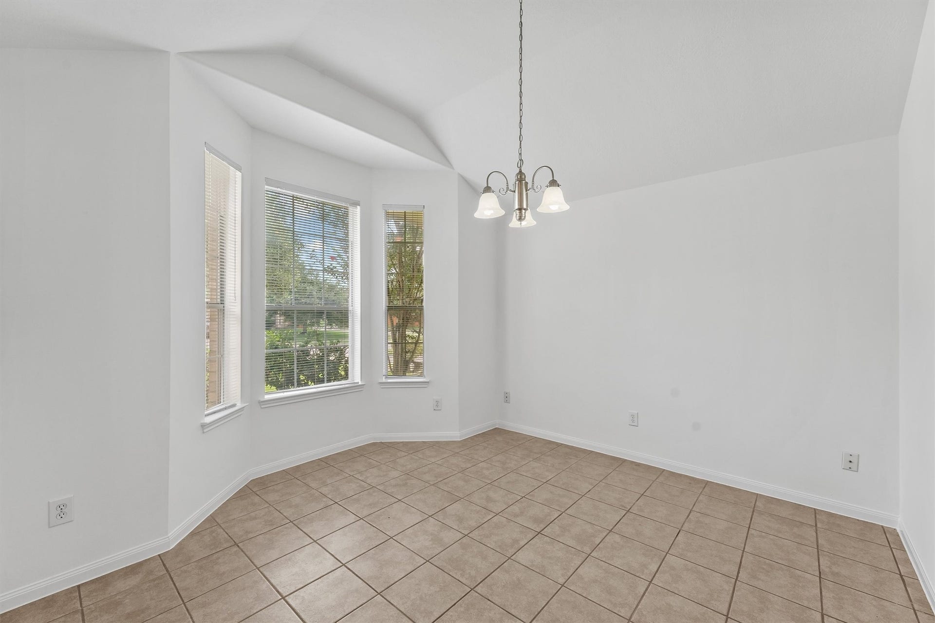 The dining room has boasts a bay window which lets the outside in.