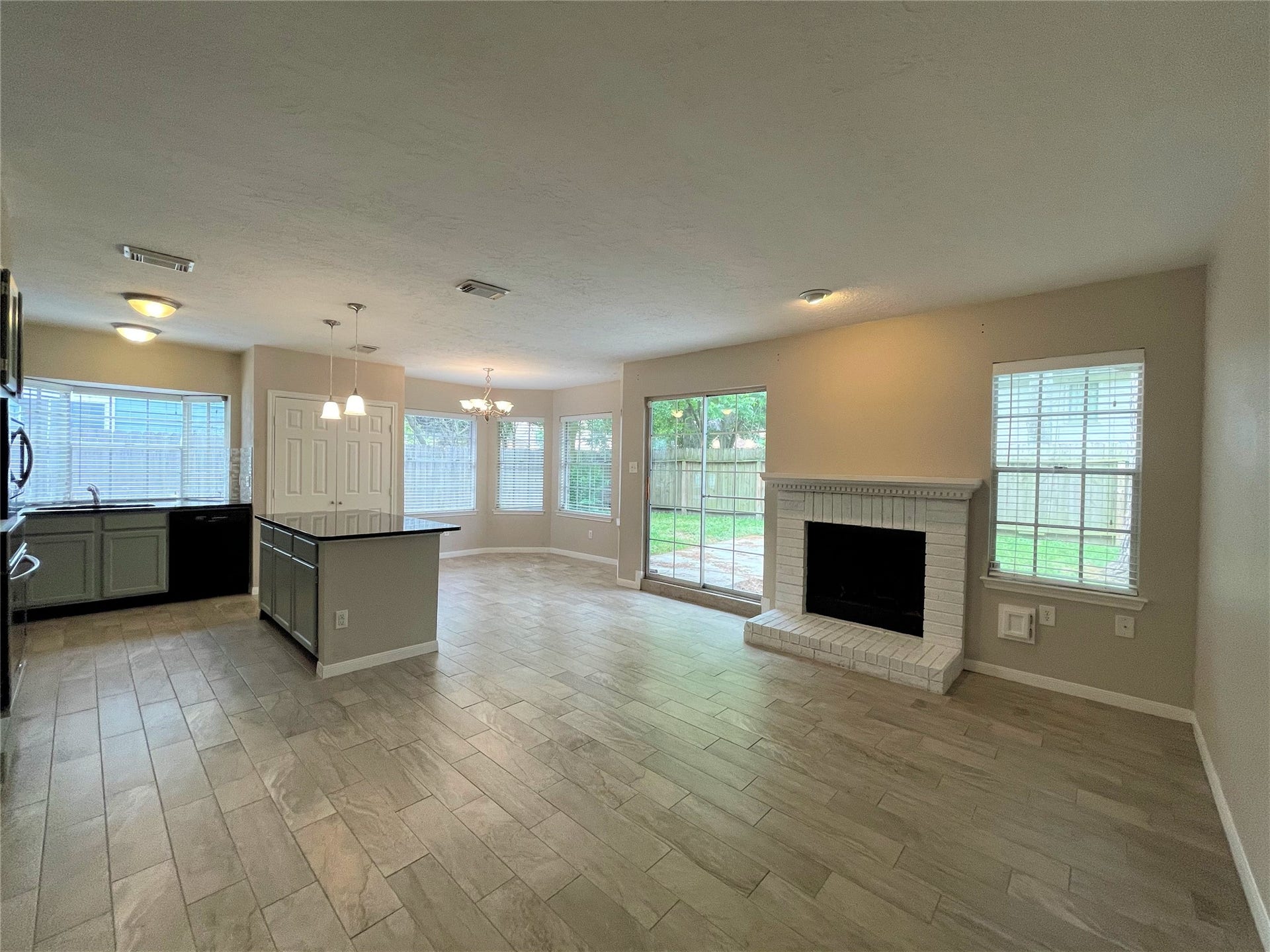 8406 Lake Crystal Drive, Houston, TX 77095 The spacious open-plan living area seamlessly combines comfort and style. This thoughtfully designed space features a fireplace and large windows that flood the room with natural light, making it feel airy and inviting.