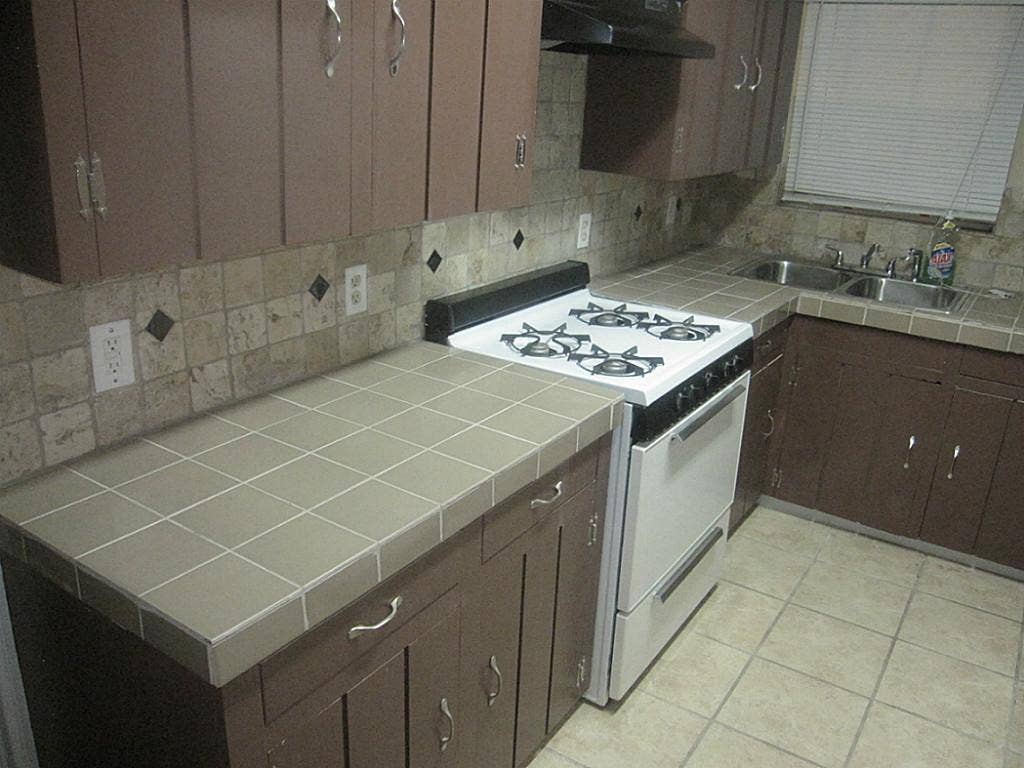 225 Nanlee Street, La Marque, TX 77568 Tiled countertops and flooring throughout kitchen