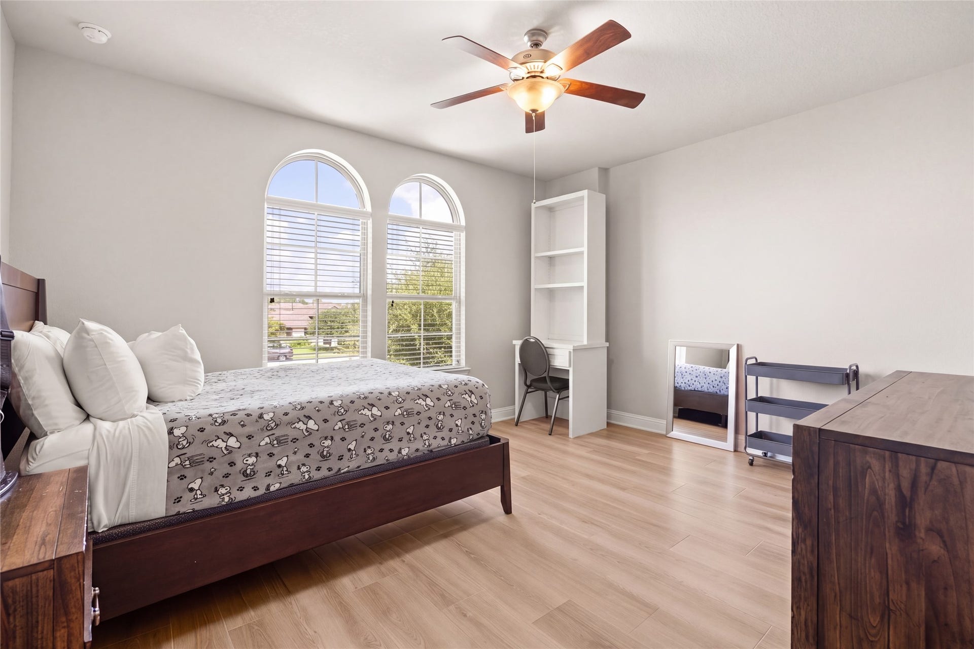 SECONDARY BEDROOM  Spacious secondary bedroom with charming arched windows, abundant natural light, and room for a study or sitting area.
