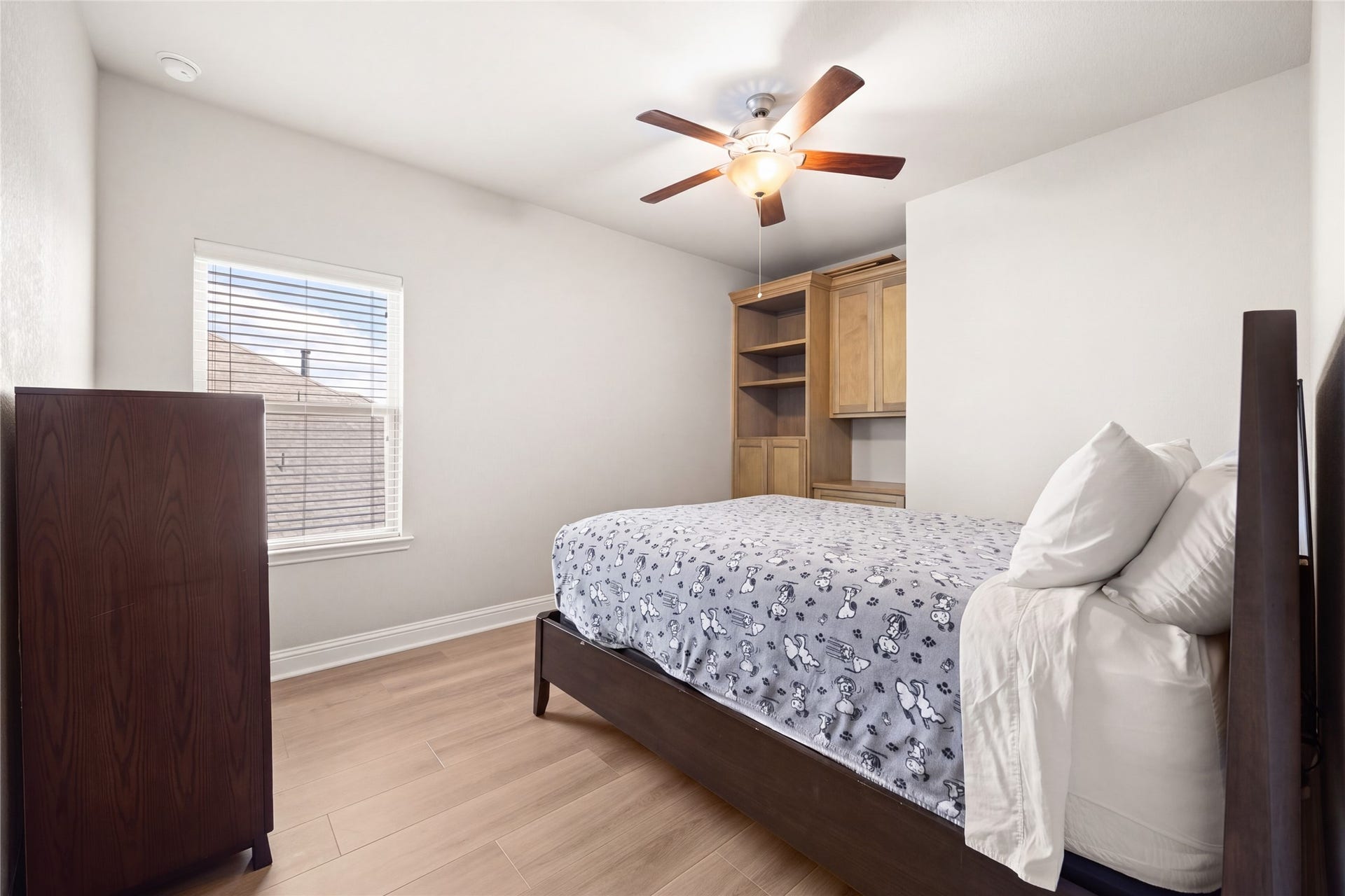 SECONDARY BEDROOM  Upstairs secondary bedroom with a ceiling fan, and built-in cabinetry for additional storage.