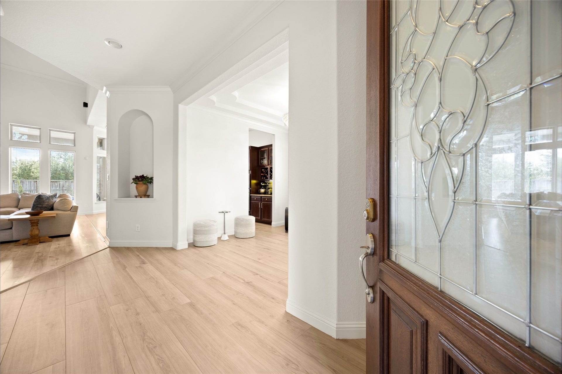 ENTRY  A bright, welcoming entry with light wood-like tile flooring, and an open flow into the home's main living spaces.