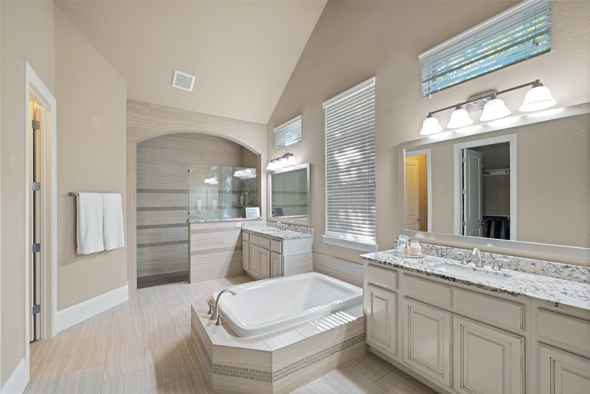 12606 Whitney Court, Magnolia, TX 77354 The spacious primary bath features separate vanities and a large walk-in shower with minimal glass for easier maintenance.