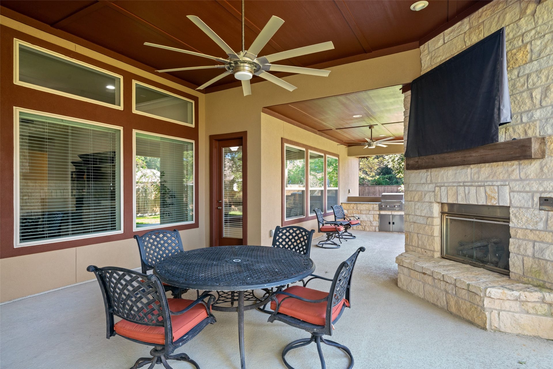 12606 Whitney Court, Magnolia, TX 77354 An oversized covered patio with an outdoor fireplace and kitchen extends the living space outdoors for year-round entertaining.