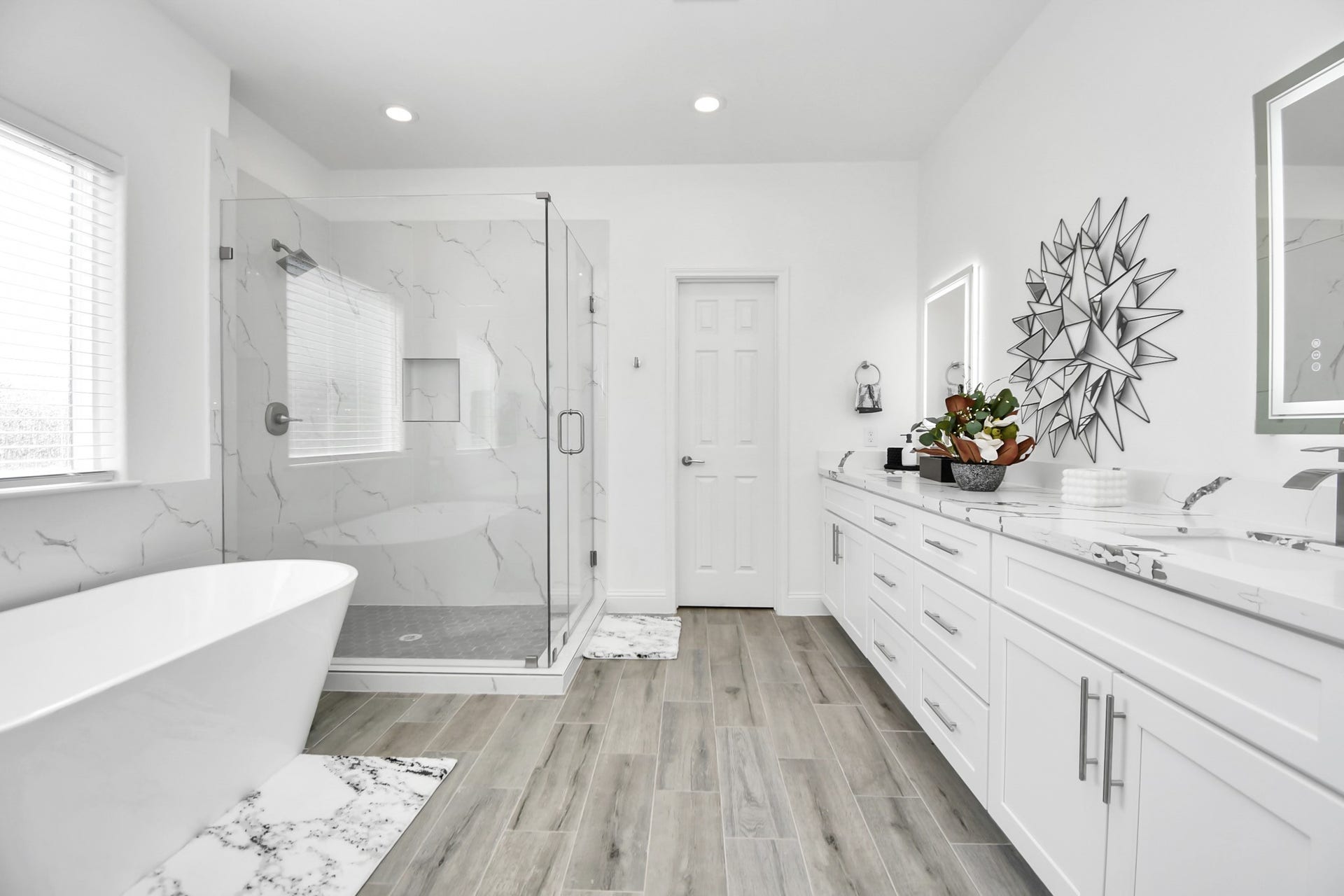 7812 Jester Street, Houston, TX 77051 A spa-inspired ensuite pairs an expansive dual-sink vanity with a glass-enclosed shower and freestanding soaking tub, all presented in an elegant white-and-modern palette.