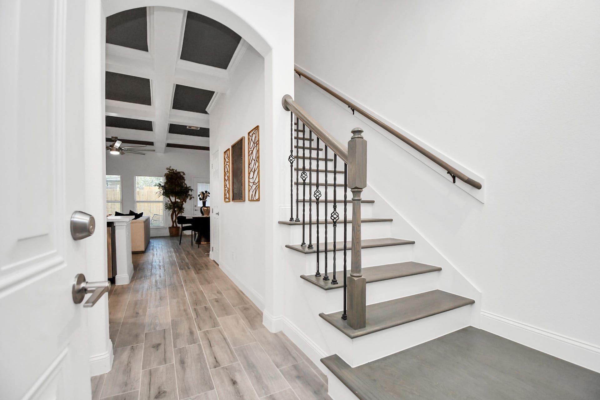 7812 Jester Street, Houston, TX 77051 From the front door, an elegant staircase and graceful archway draw the eye toward the home's main living spaces, offering an immediate glimpse of the refined design beyond.