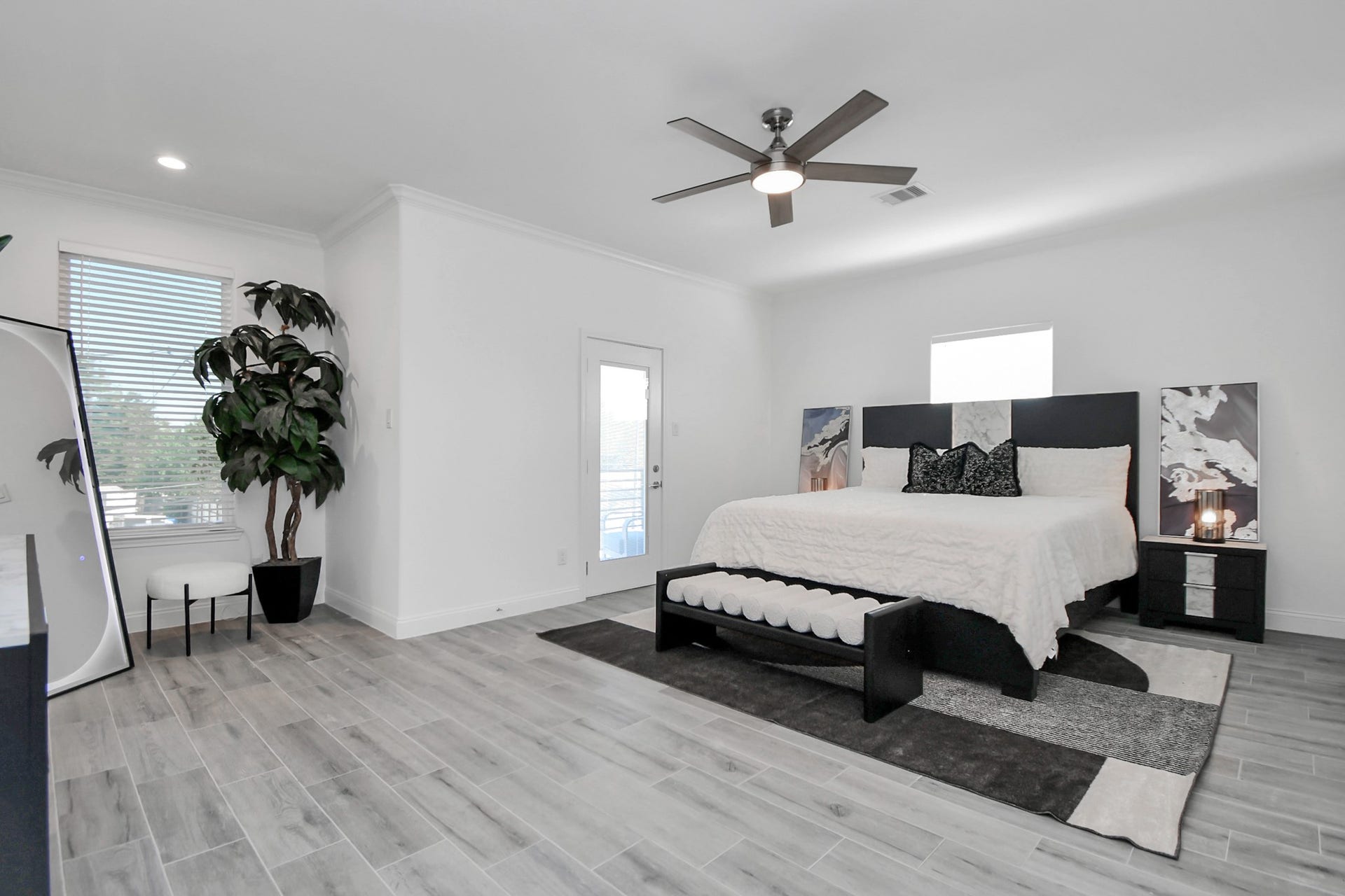 7812 Jester Street, Houston, TX 77051 Recessed lighting and crown molding detail the spacious primary suite, complete with direct access to an elevated private balcony via a glass door.