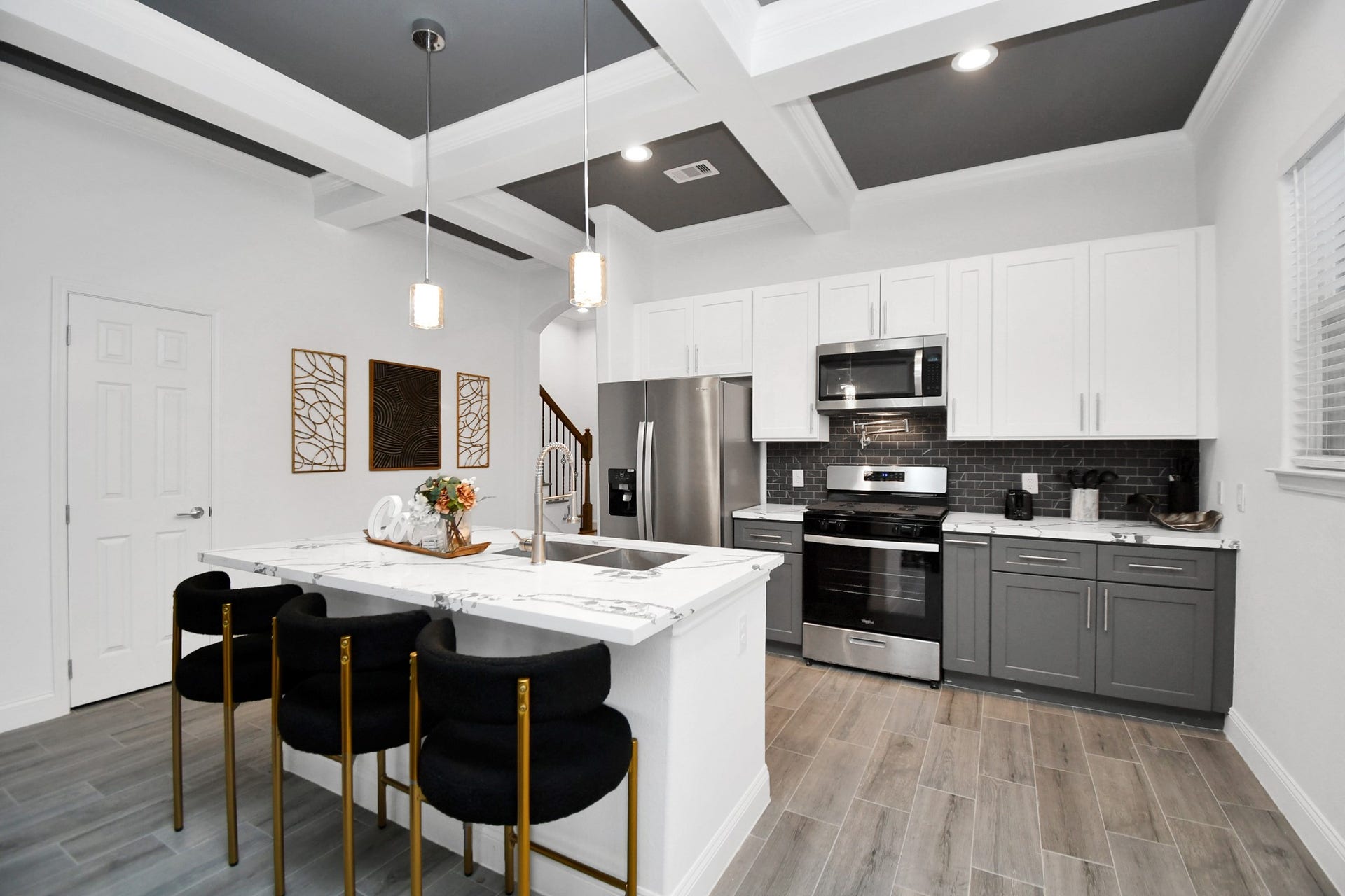 7812 Jester Street, Houston, TX 77051 Designed to command attention, the kitchen features a substantial island with seating, two-tone gray and white cabinetry, a beautifully detailed backsplash, and complementary countertops that elevate the space.