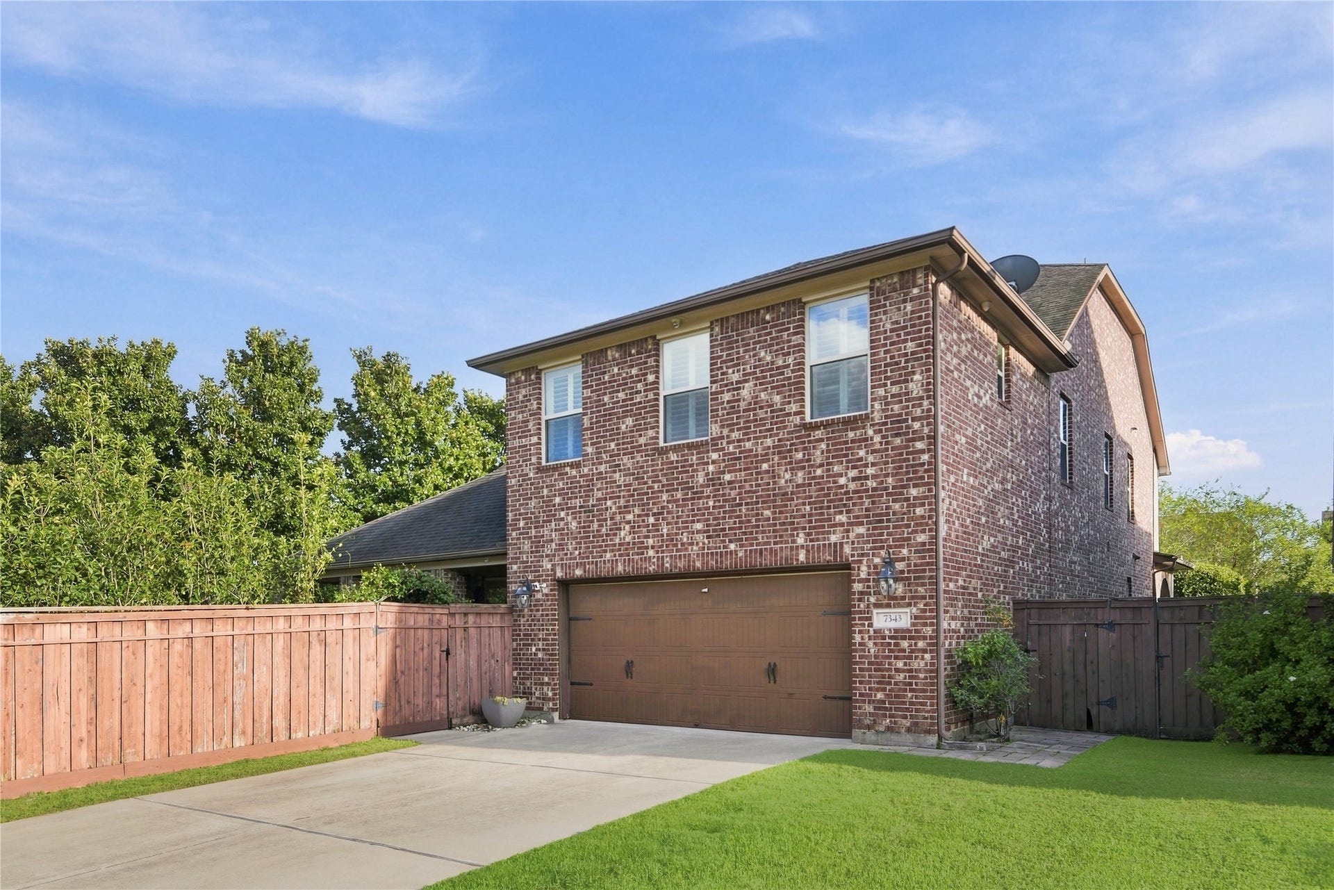 7343 Meadowcroft Boulevard, Sugar Land, TX 77479 Spacious tandem three-car garage with a private driveway for additional parking, nestled in the back of the home surrounded by lush greenery.