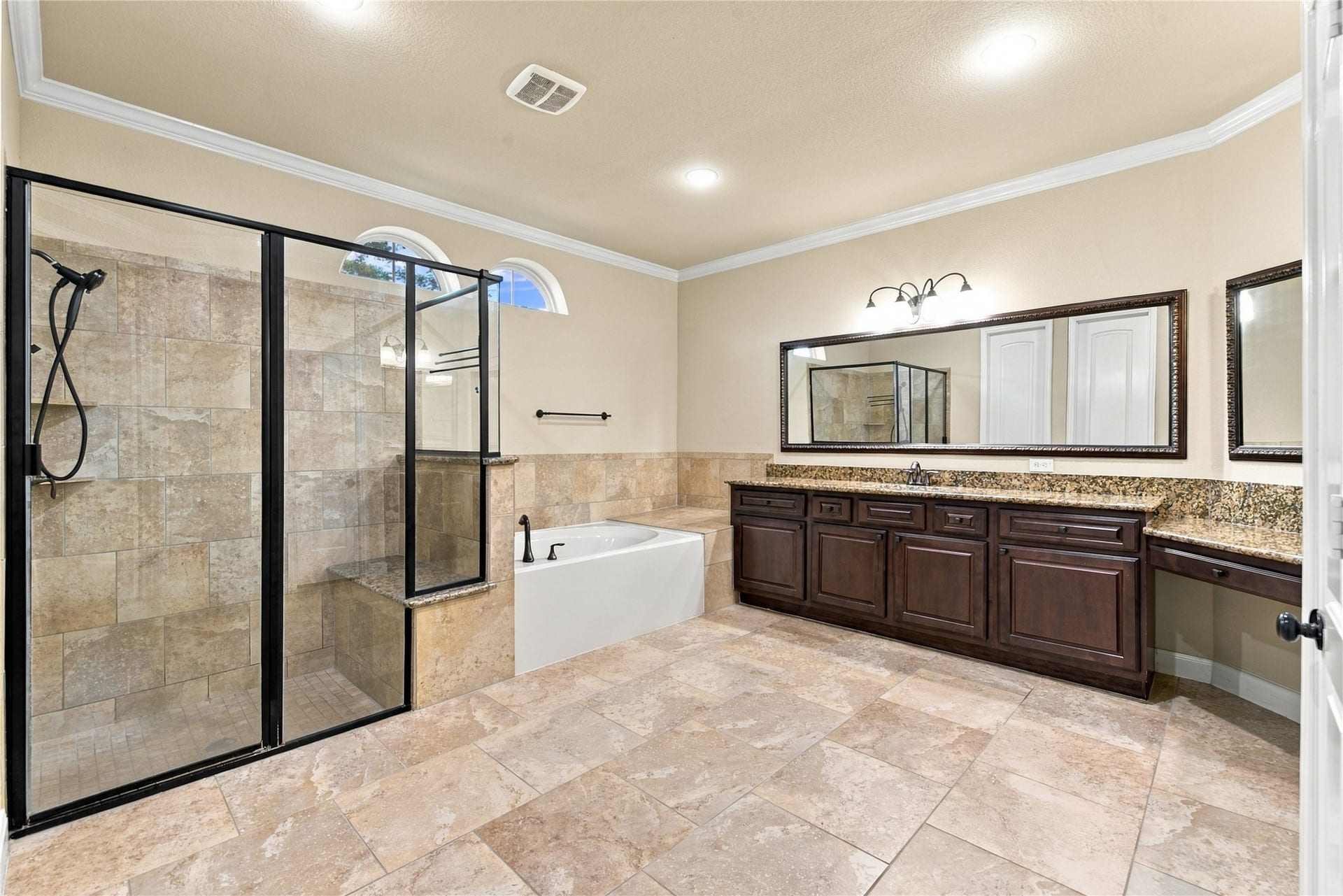7343 Meadowcroft Boulevard, Sugar Land, TX 77479 Spacious primary bathroom featuring a large walk-in shower, relaxing soaking tub, and rich wood cabinetry with granite countertops.