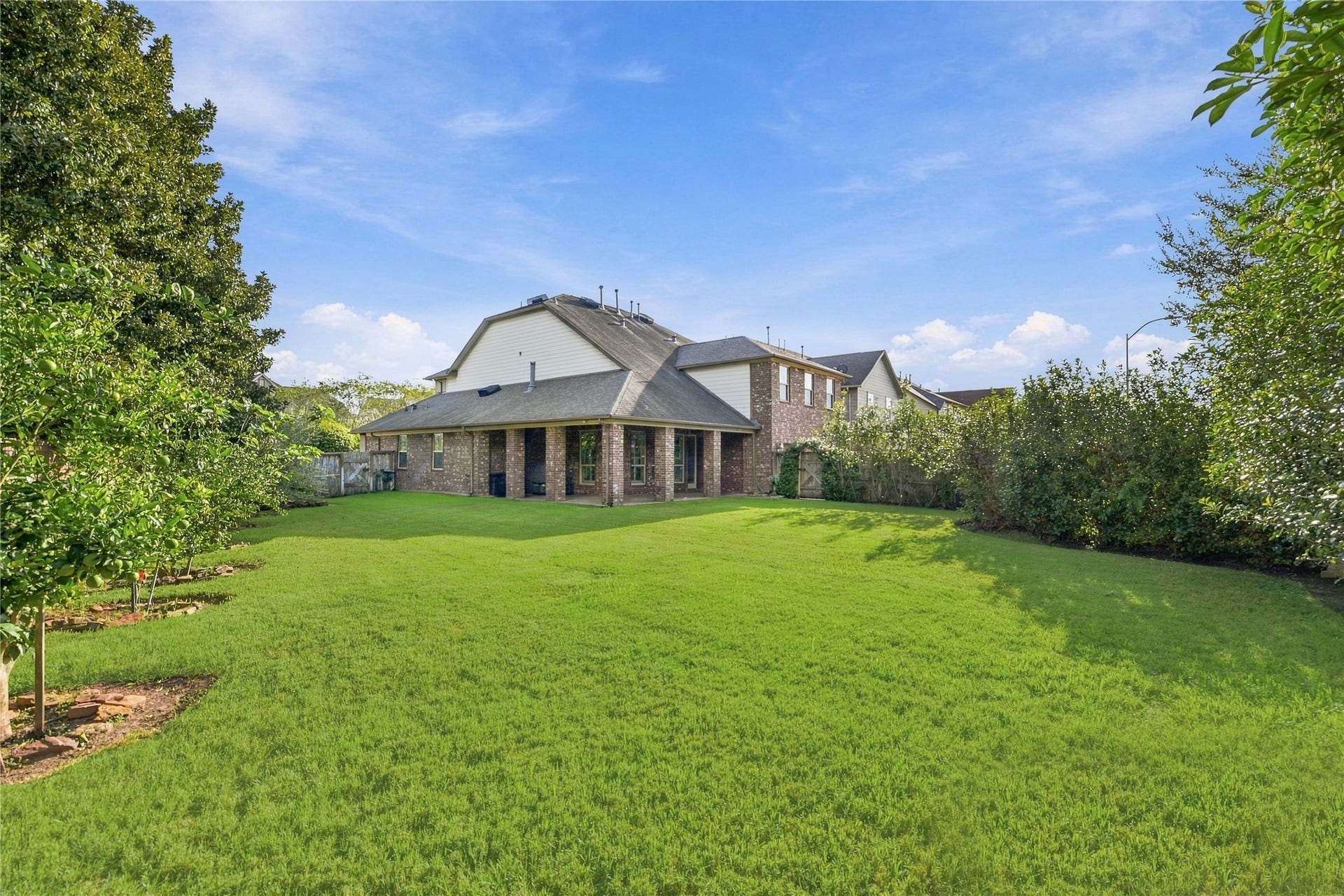 7343 Meadowcroft Boulevard, Sugar Land, TX 77479 Expansive backyard with lush green lawn and mature trees, offering a ton of privacy and a perfect outdoor retreat.