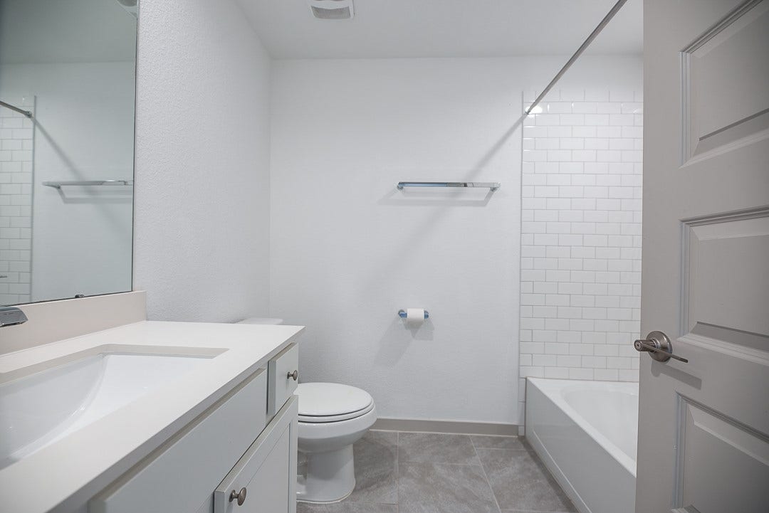 6906 Halifax Harvest Lane, Richmond, TX 77407 Modern bathroom featuring a spacious vanity with ample storage, and a classic white subway tile shower.