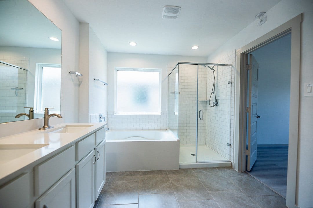 6906 Halifax Harvest Lane, Richmond, TX 77407 Luxurious primary bathroom with a separate shower and soaking tub, dual sinks, and a spacious walk-in closet.