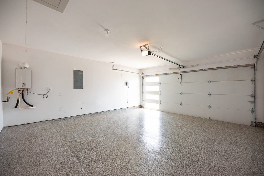 6906 Halifax Harvest Lane, Richmond, TX 77407 The perfect blend of durability and style with this spacious garage featuring a sleek epoxy floor, ideal for both storage and projects.
