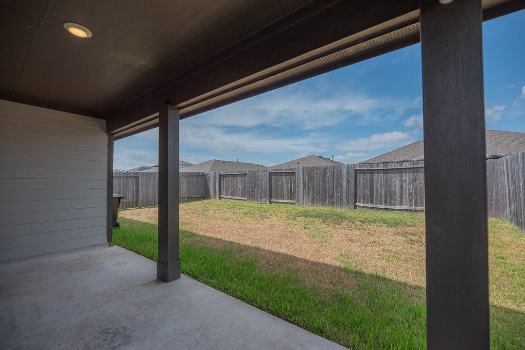 6906 Halifax Harvest Lane, Richmond, TX 77407 Outdoor living with a spacious backyard complete with a cozy covered patio, perfect for relaxation and entertaining.