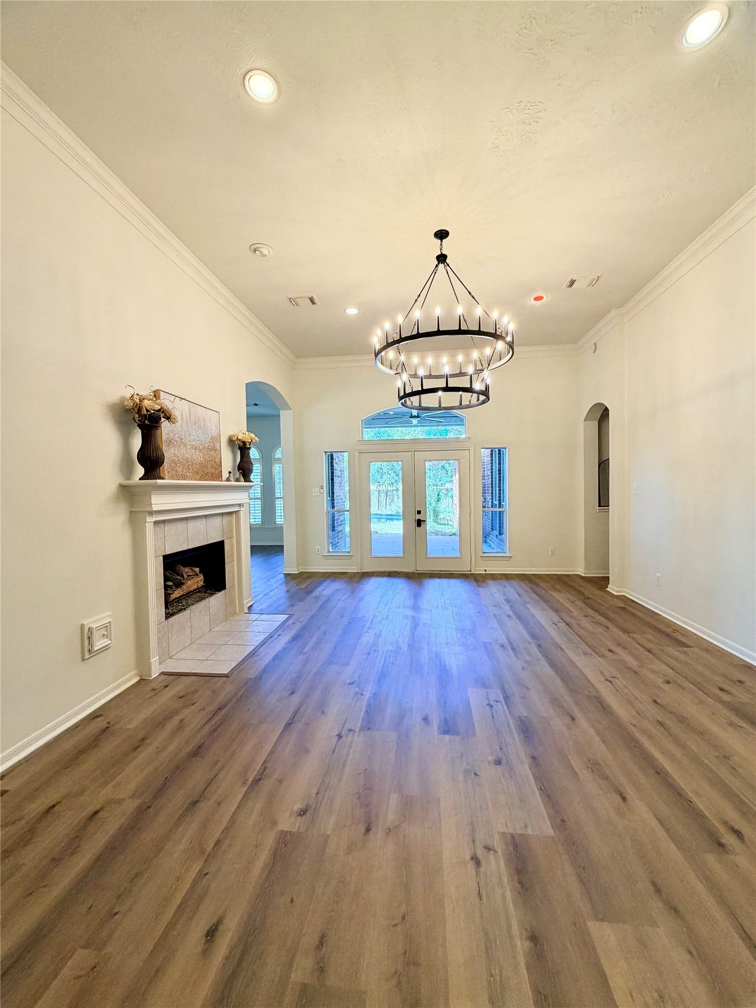 20434 Long Cypress Drive, Spring, TX 77388 View of the Living room from the foyer. Notice the high ceiling, French doors to the covered patio, recessed lighting, and the gas log fireplace. The family room is to the left and the Primary bedroom is to the right.