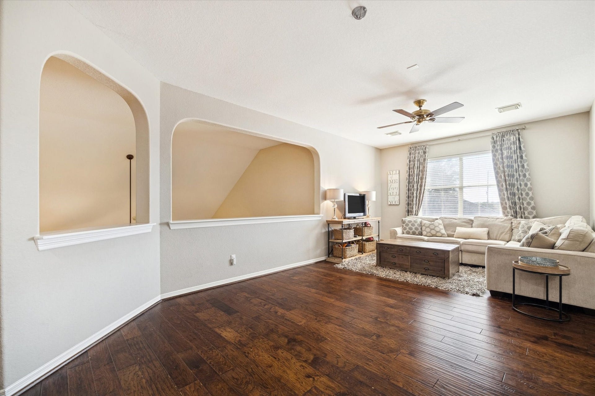 VERSATILE UPSTAIRS LIVING SPACE WITH OPEN ARCHITECTURAL DETAILS, PERFECT FOR A GAME ROOM, MEDIA SPACE, OR SECONDARY LIVING AREA.