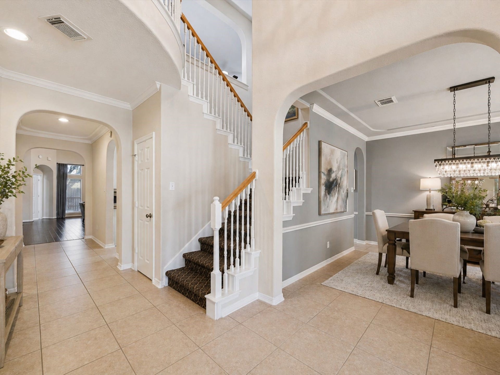 GRAND ENTRY WITH HIGH CEILINGS, CURVED STAIRCASE, AND ARCHITECTURAL DETAILS THROUGHOUT.