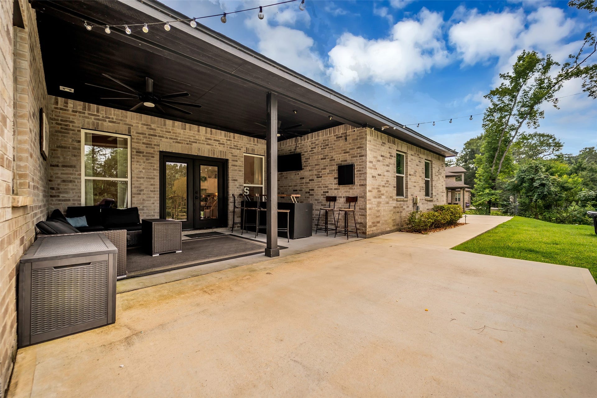14663 Diamond Shores, Willis, TX 77378 Covered back patio with string lights and outdoor living area. Perfect for a cup of coffee