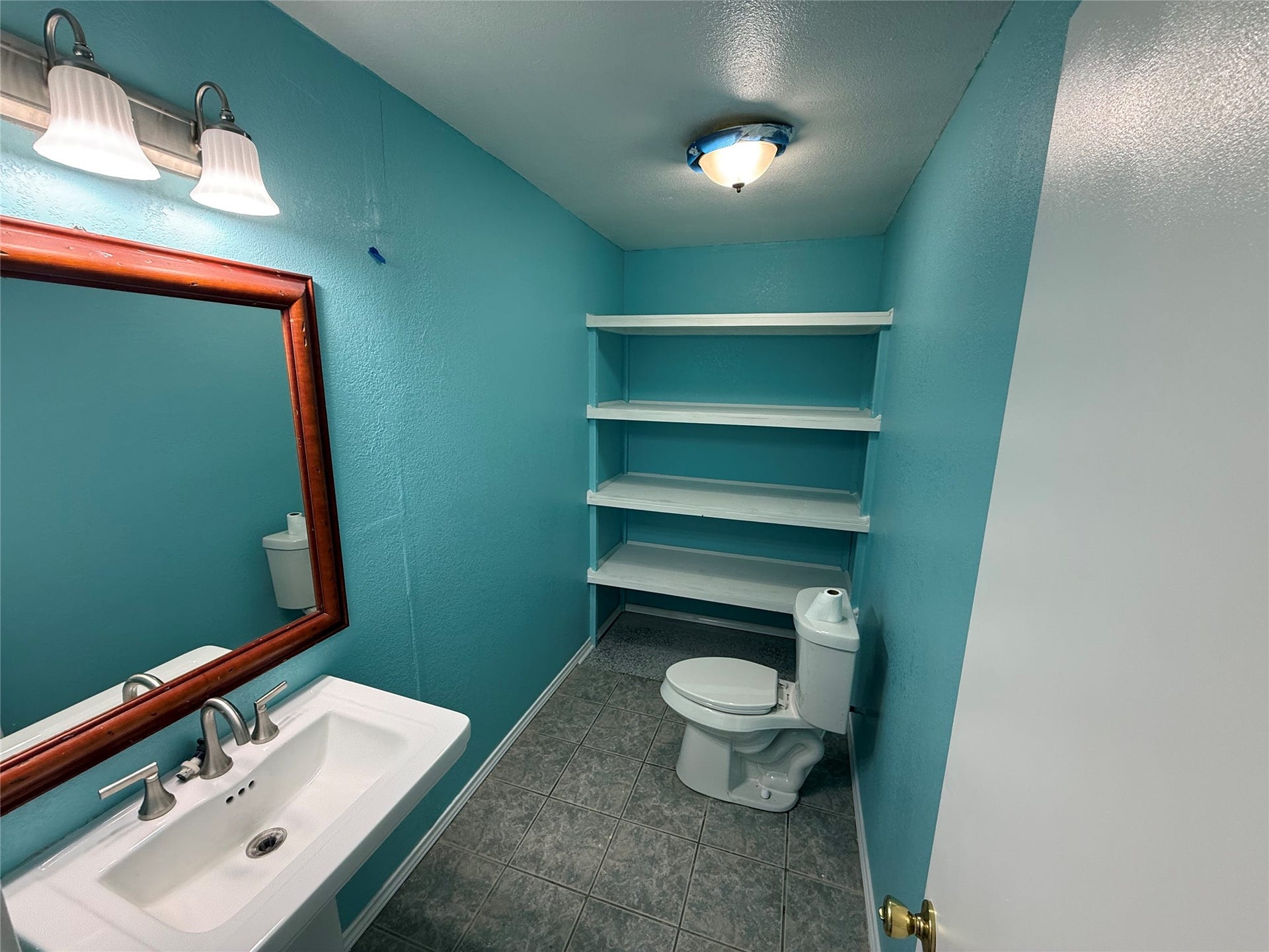 2524 Shouse Road, Santa Fe, TX 77510 Bathroom with a framed mirror, vanity, and open shelving above the toilet.