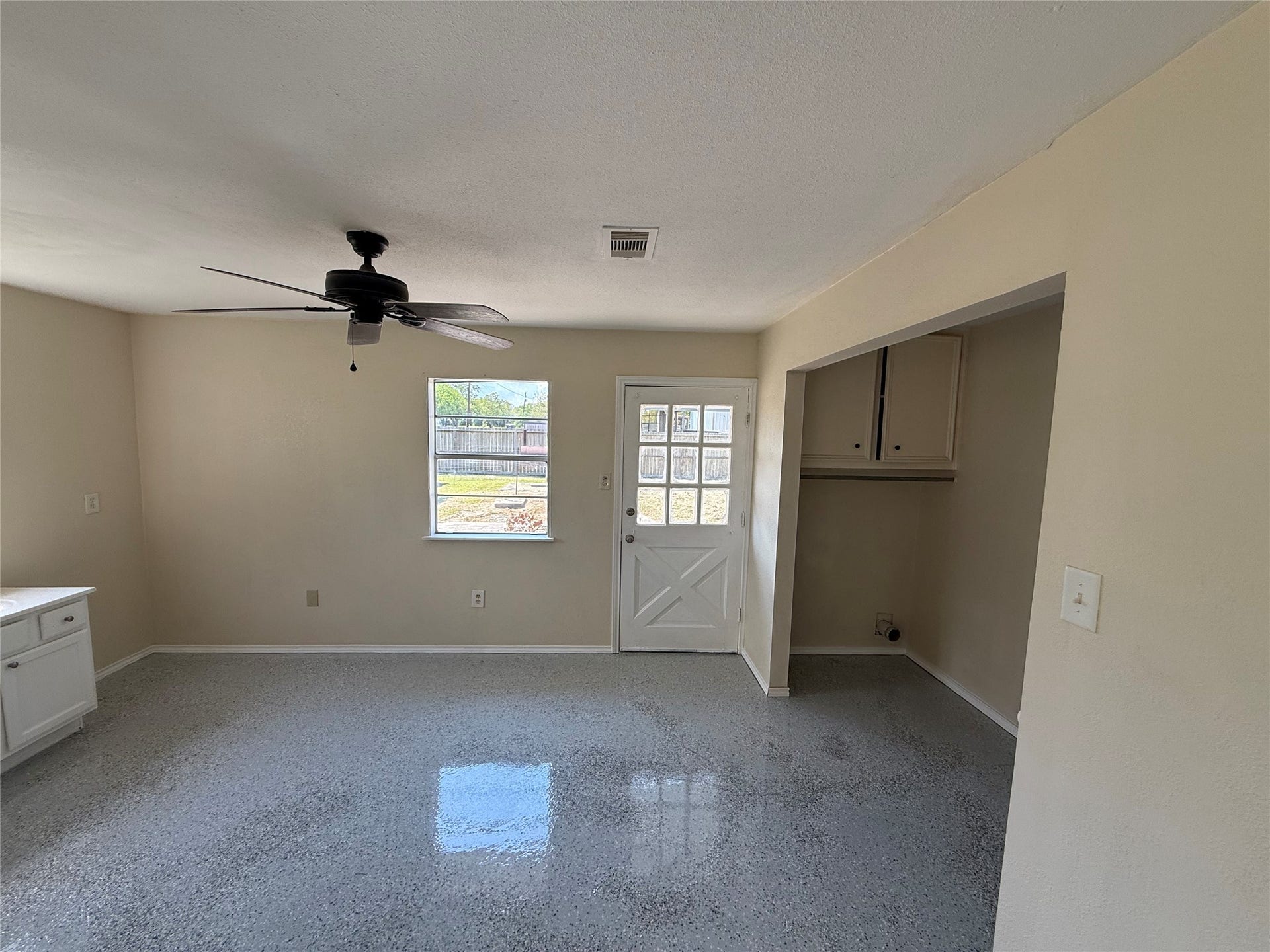 2524 Shouse Road, Santa Fe, TX 77510 Tiled room with natural light, a ceiling fan, and an adjacent utility alcove.
