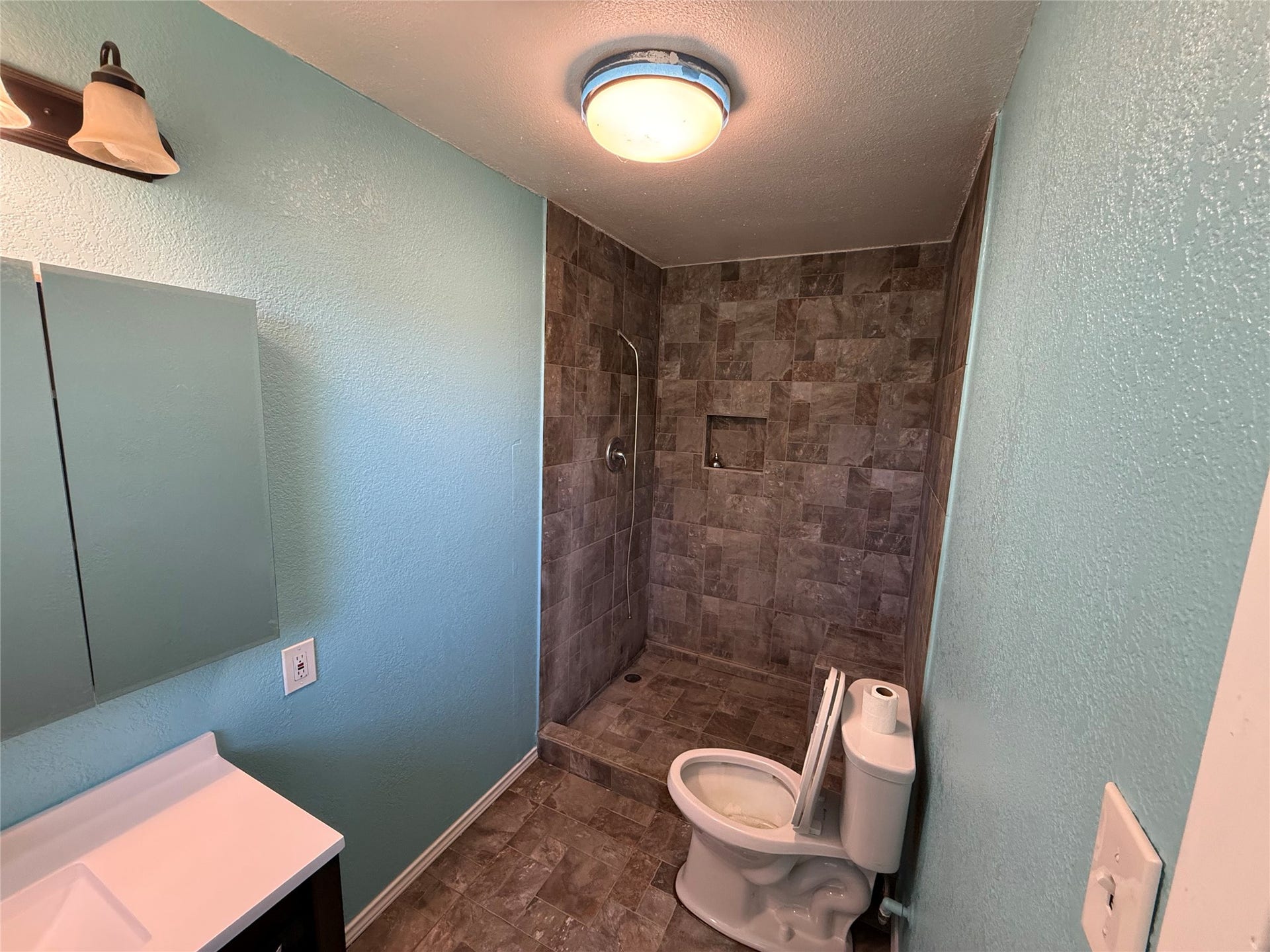 2524 Shouse Road, Santa Fe, TX 77510 Bathroom featuring a mirrored cabinet and a stone-look accent wall.