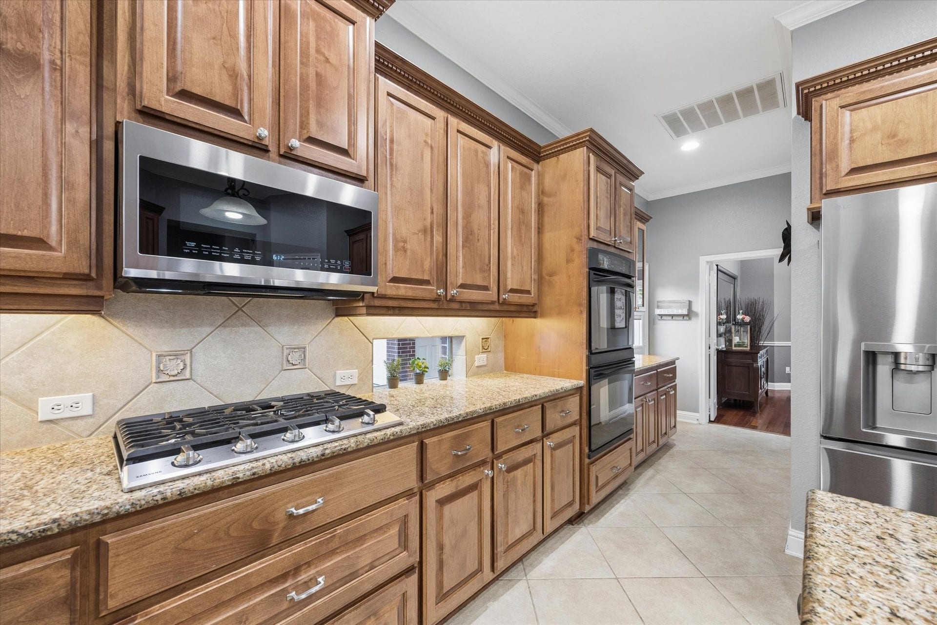 3523 Silvercreek Drive, Manvel, TX 77578 Gas stainless cooktop, stainless microwave and double electric ovens complete this cook's kitchen