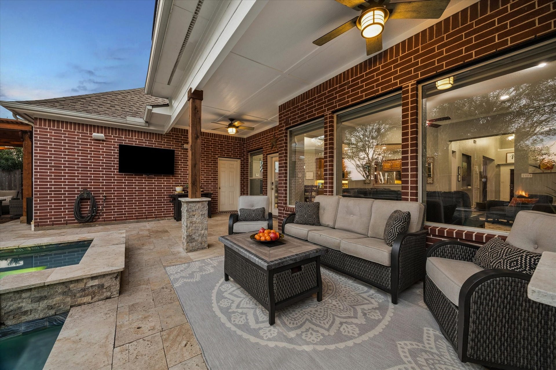 3523 Silvercreek Drive, Manvel, TX 77578 Covered patio off the living room with limestone flooring overlooking the pool and spa