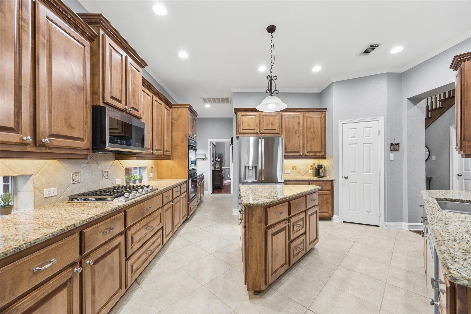 3523 Silvercreek Drive, Manvel, TX 77578 Kitchen designed with transom windows to bring in the natural light and under cabinet lighting
