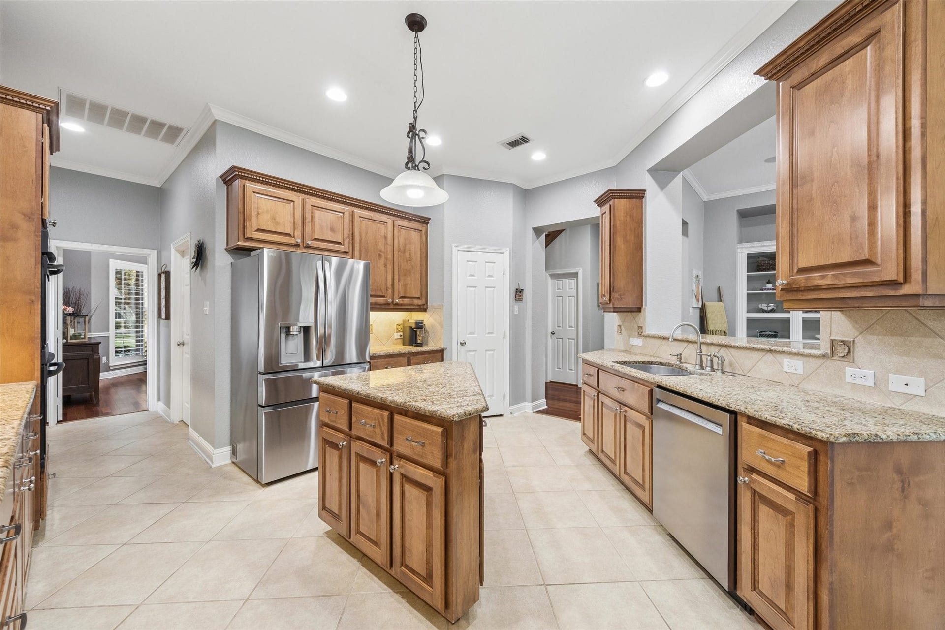 3523 Silvercreek Drive, Manvel, TX 77578 Double kitchen stainless sink, stainless dishwasher and stainless refrigerator nicely positioned for easy use