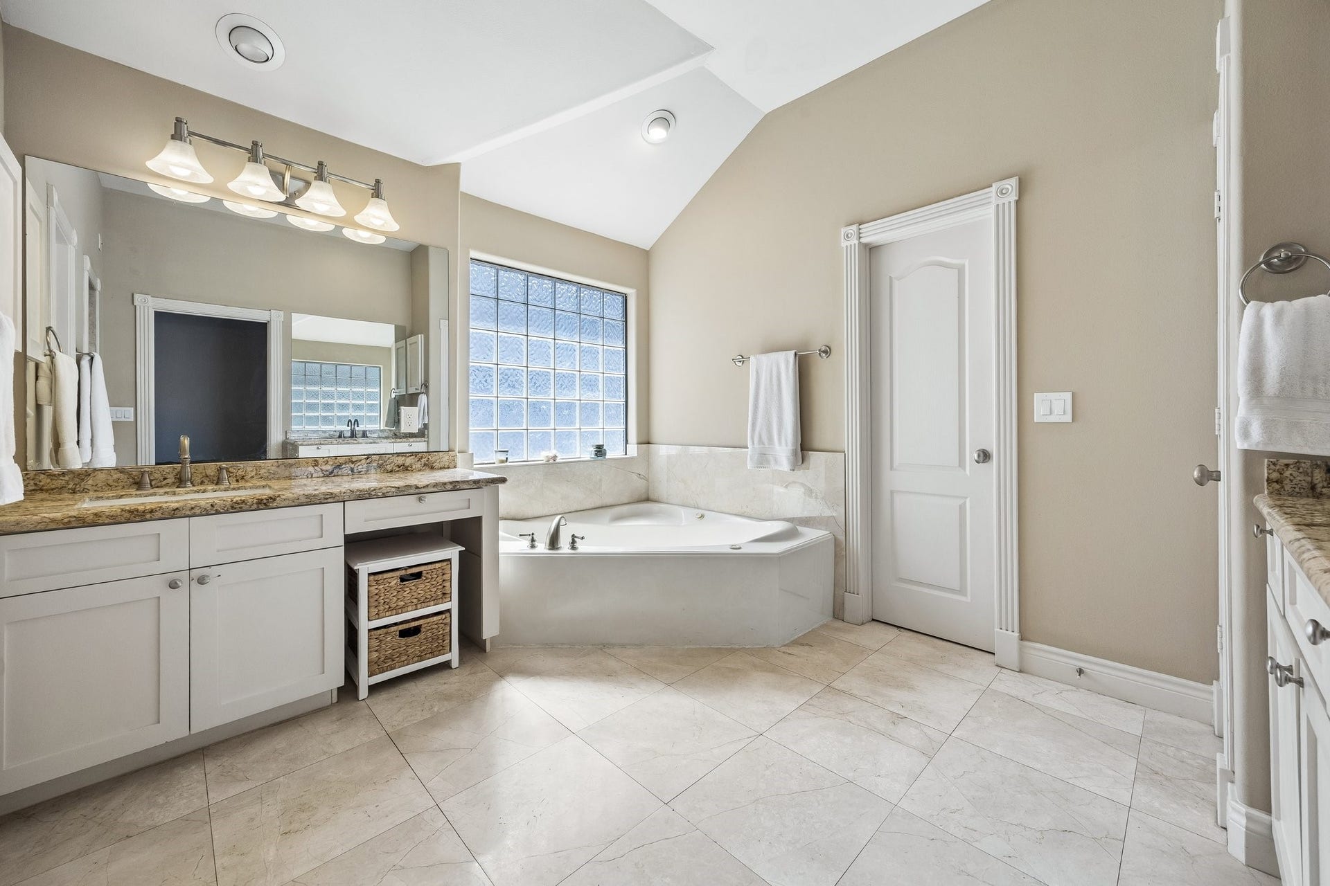 Immerse yourself in the tranquility of this spa-The space features premium finishes, a tub perfect for unwinding after a long day, and a sophisticated, modern aesthetic that promotes relaxation and wellness. Every detail, from the ambient lighting to the elegant tile work, has been thoughtfully curated to provide a high-end, therapeutic experience within the comfort of your own home.    Key Features of the Spa-Like Bath:  *   **Deep Soaking Tub:** A centerpiece designed for ultimate comfort and