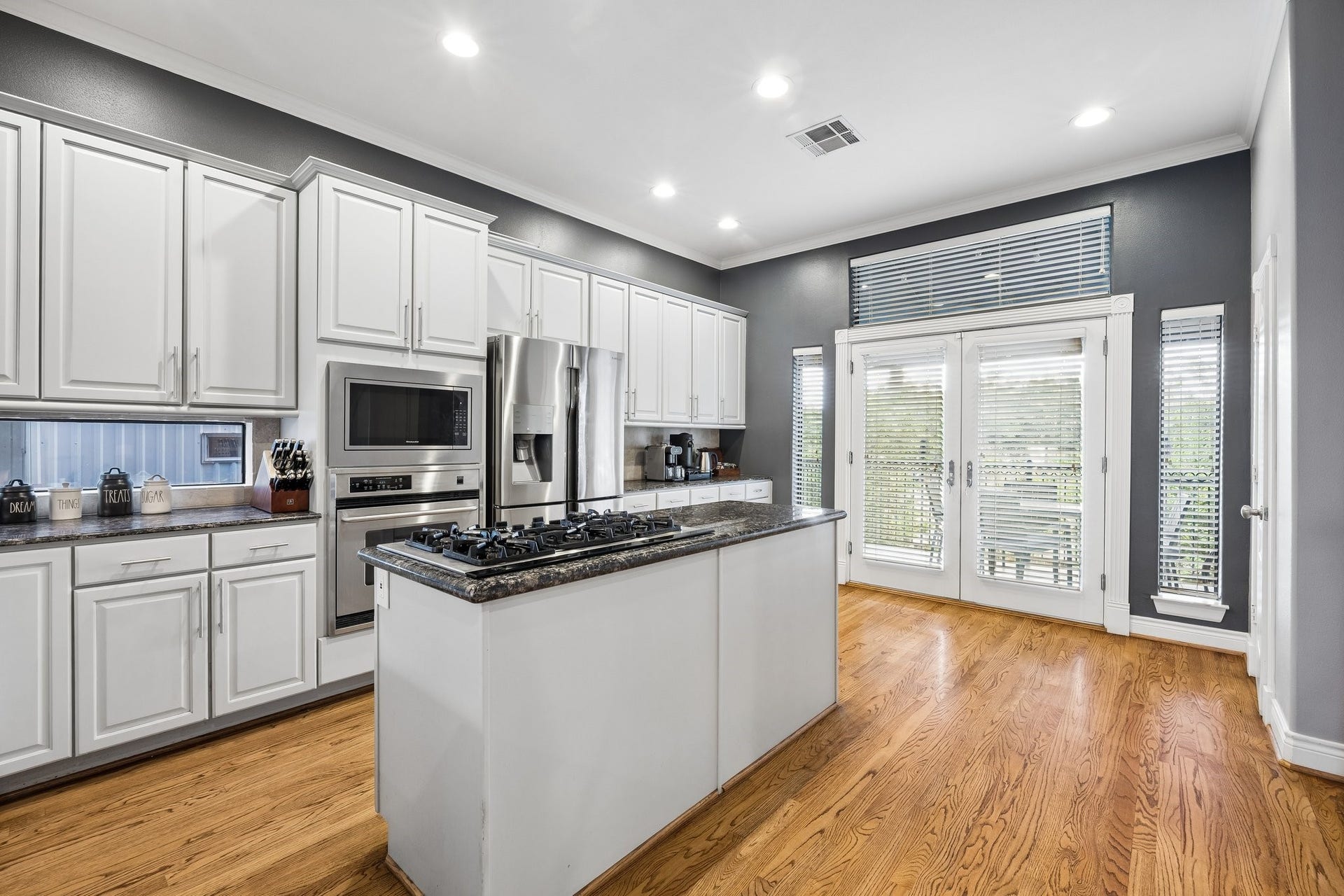The kitchen is full of natural light and features a great coffee bar area as well as a second prep area with it's window. Note the floor to ceiling windows flanking the French doors leading to the grilling area