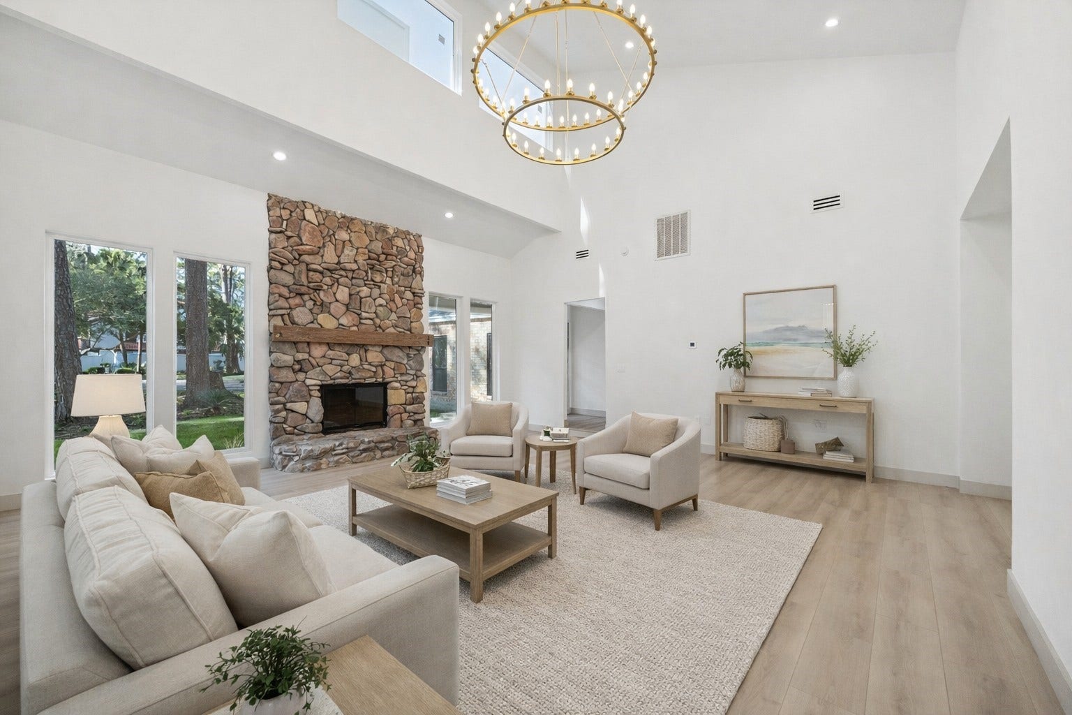 2306 Mill Lake Drive, Kingwood, TX 77339 The living room is anchored by a statement chandelier and flows seamlessly into the dining area for easy entertaining. AI staged.