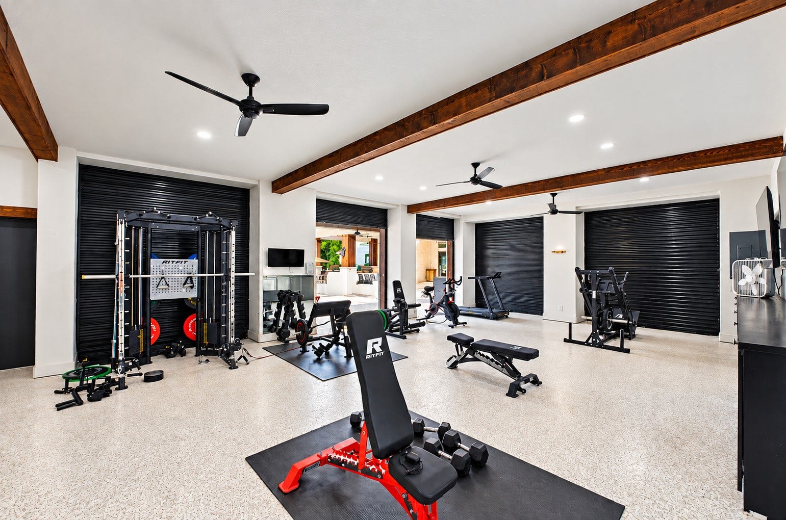37753 Marias Way, Magnolia, TX 77354 Inside the expansive metal building, a dedicated fitness area provides ample space for a full home gym, complemented by a full bath. Multiple roll-up doors provide easy access, while a separate section offers substantial additional storage.
