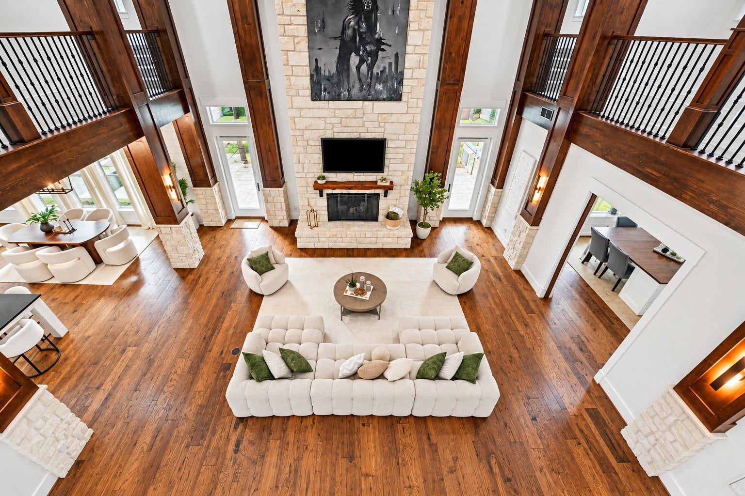 37753 Marias Way, Magnolia, TX 77354 From the second-floor overlook, the dramatic family room reveals its impressive scale, soaring windows, rich wood beams and floor-to-ceiling stone fireplace below.