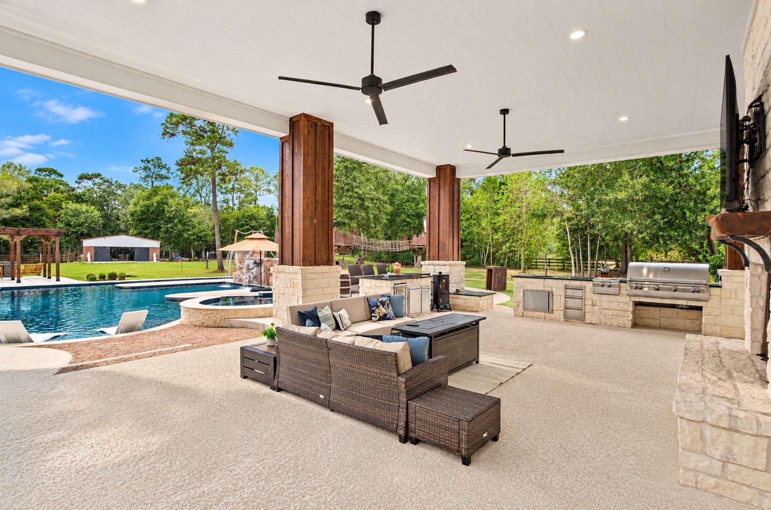 37753 Marias Way, Magnolia, TX 77354 Expansive covered outdoor living overlooks the pool and offers multiple seating areas, ceiling fans and an outdoor fireplace, creating plenty of space for year-round entertaining and relaxation.