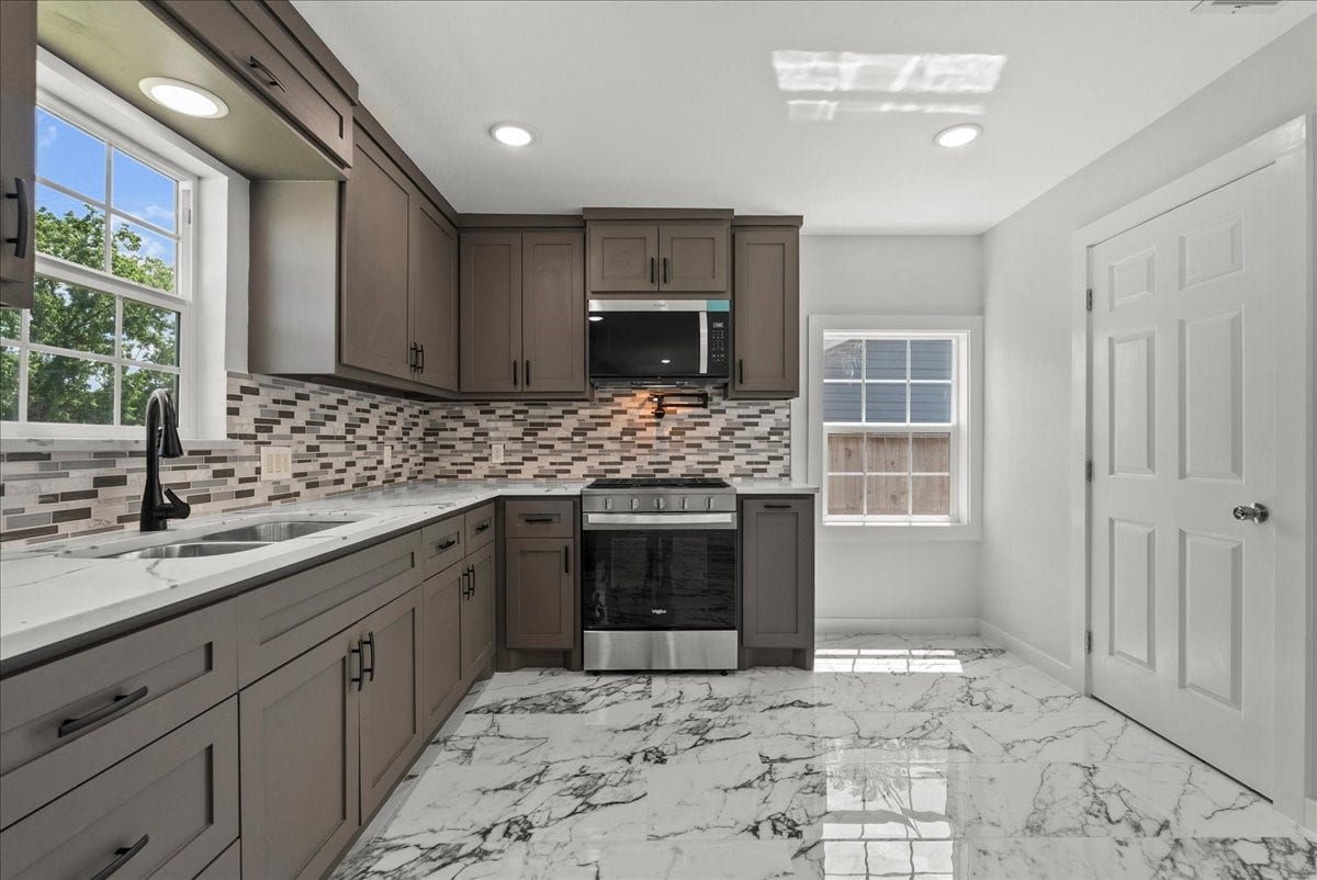 1105 W Ellaine Avenue, Pasadena, TX 77506 Modern kitchen featuring custom cabinetry, tile backsplash, and generous counter space.
