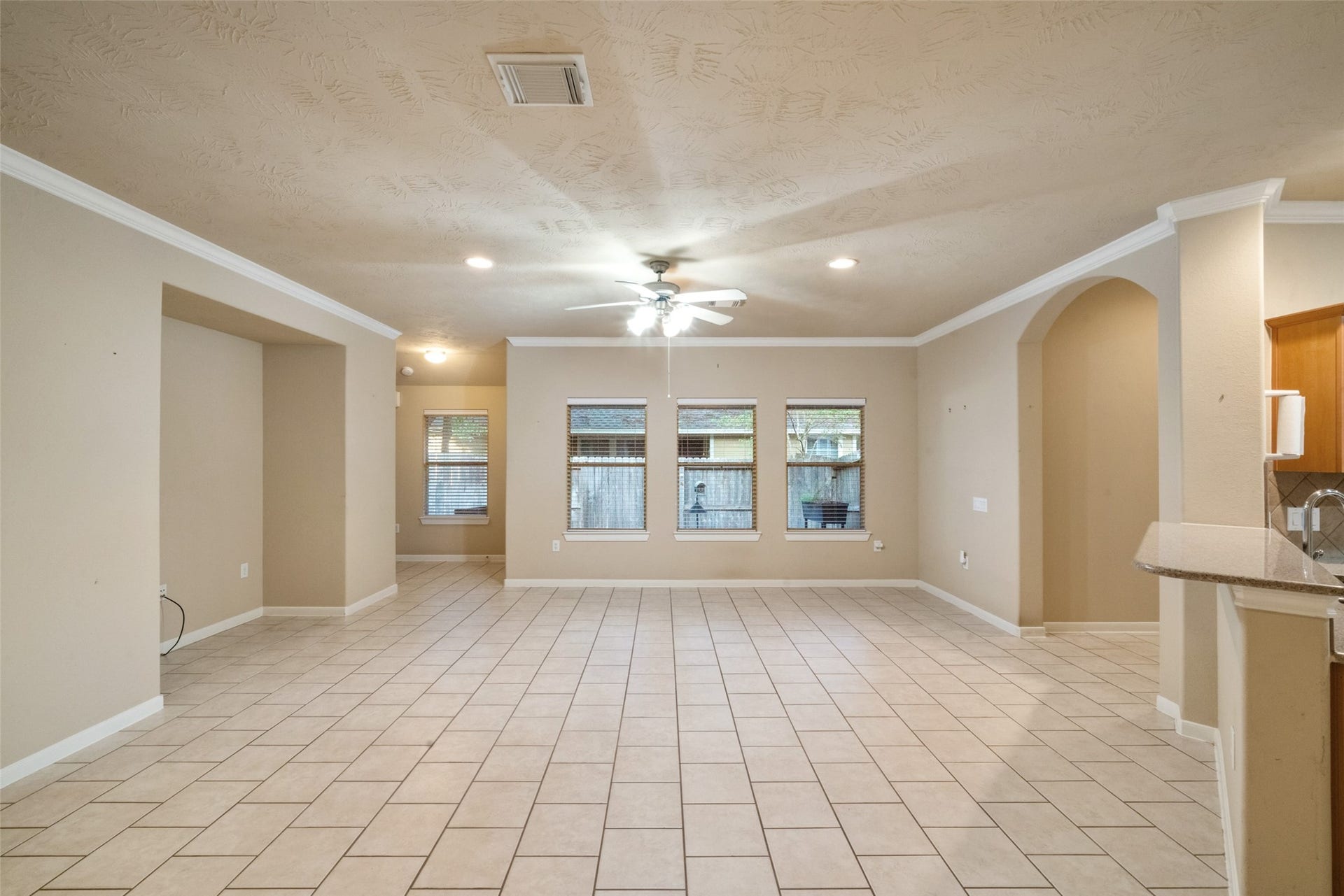 7 Fitzroy Place, Conroe, TX 77384 Spacious living room with bright windows, ceiling fan and entertainment nook