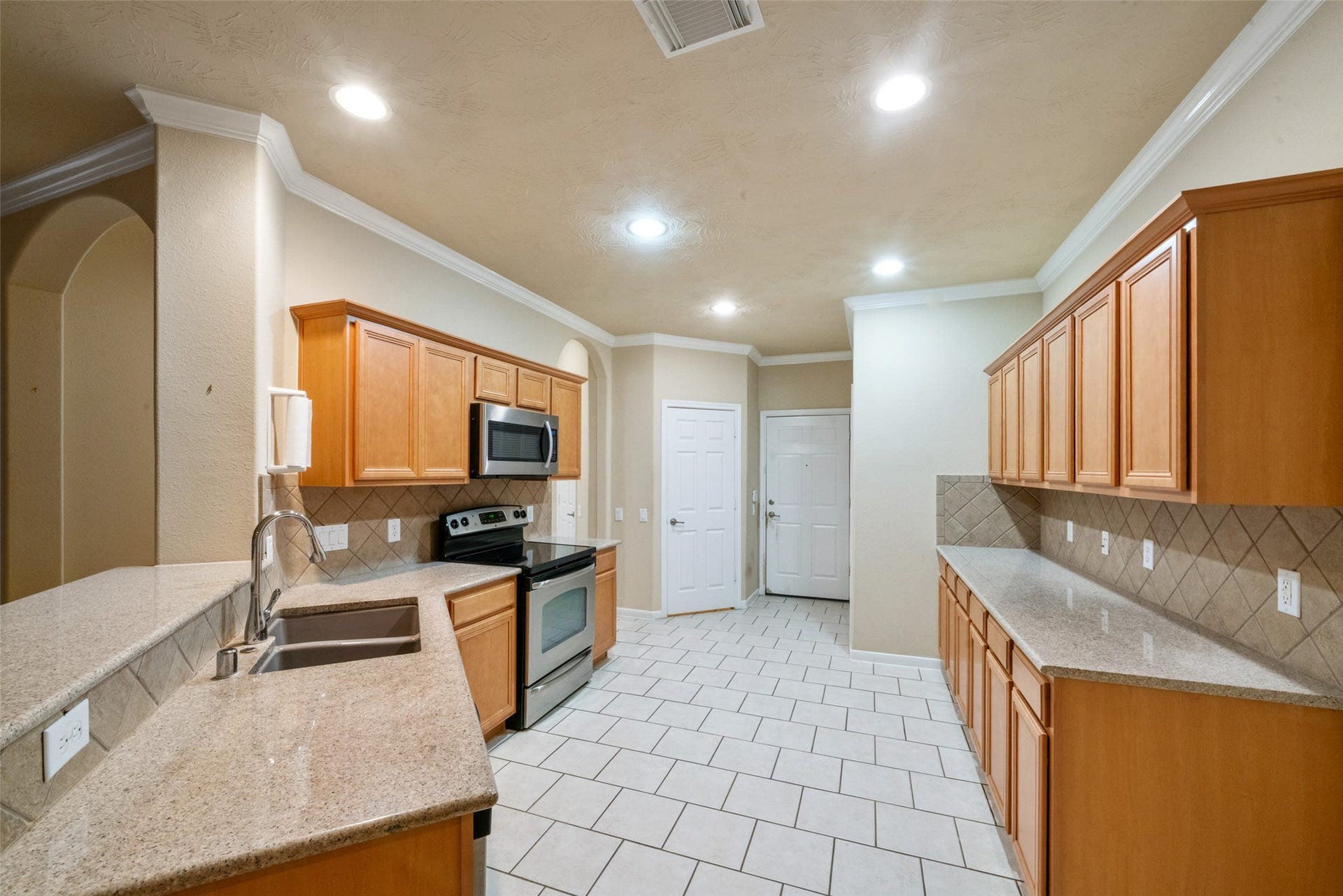 7 Fitzroy Place, Conroe, TX 77384 Notice the long counter space and expansive cabinets. The walk in pantry and garage entry door can be seen at the back of the photo.