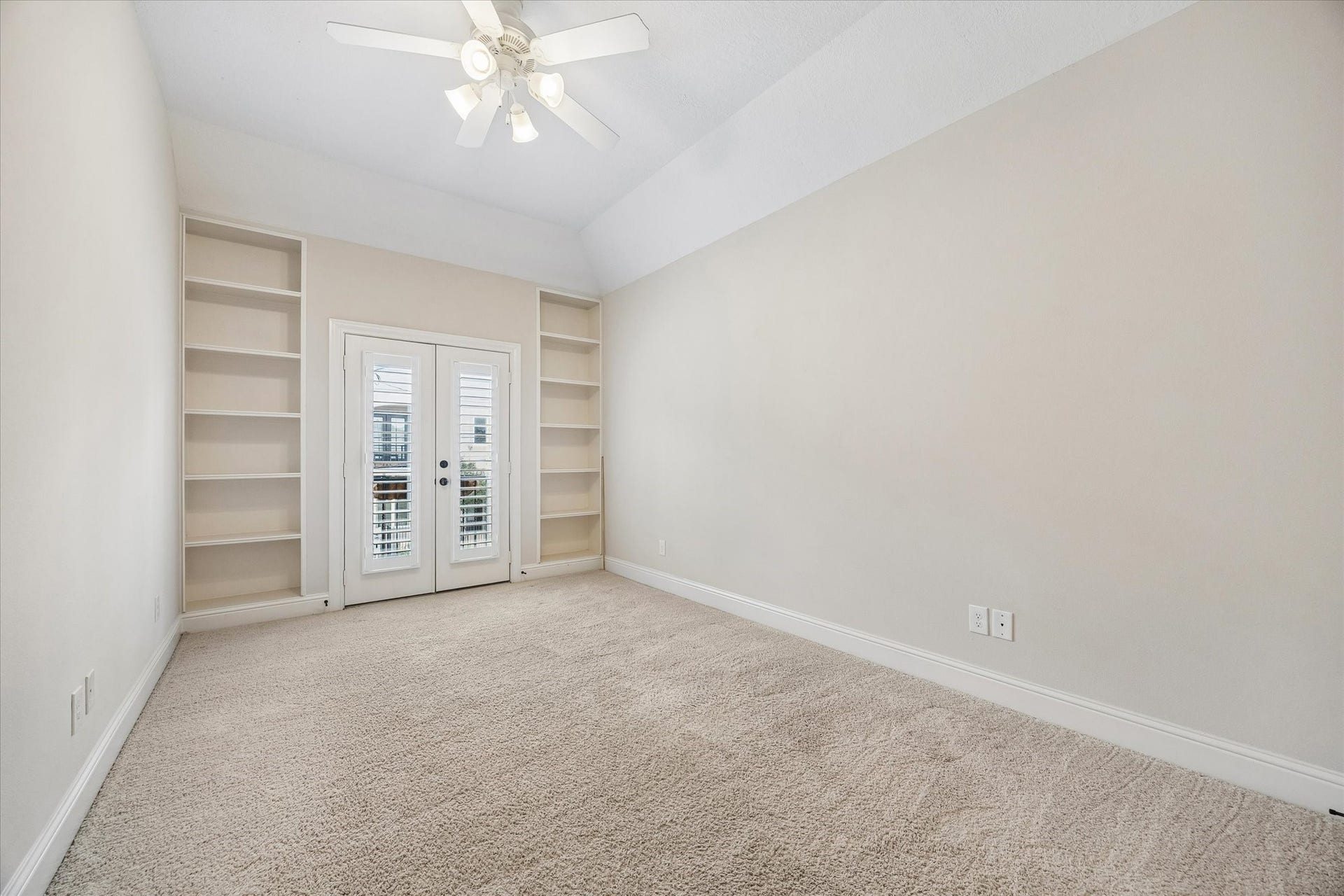 5513 Petty Street, #C, Houston, TX 77007 Secondary bedroom with vaulted ceiling, built-in shelving, and private balcony access.