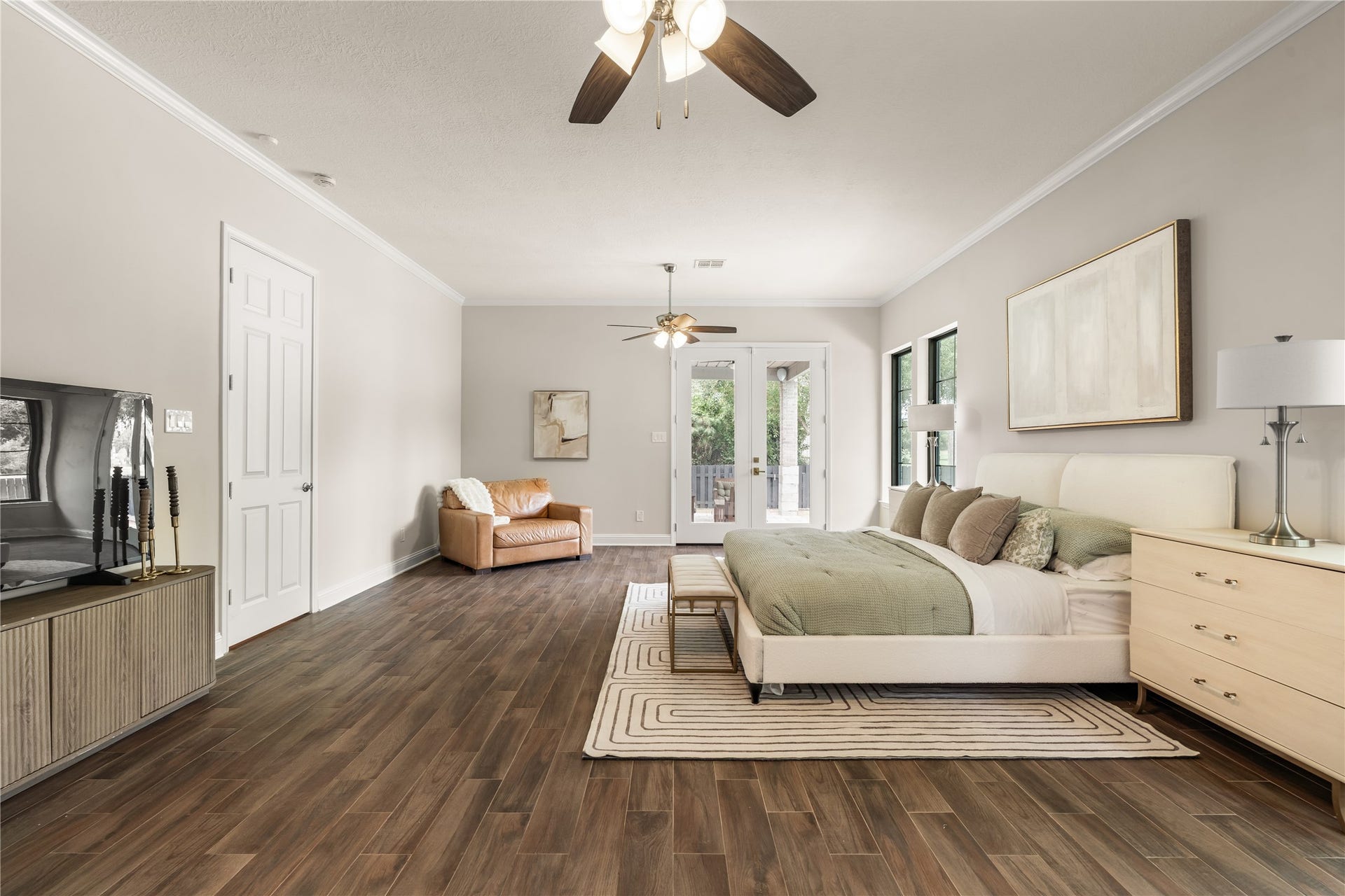 4719 Breezy Point Drive, Houston, TX 77345 The primary bedroom offers an airy, refined atmosphere with abundant room for a sitting area and French doors extending the living space outdoors.