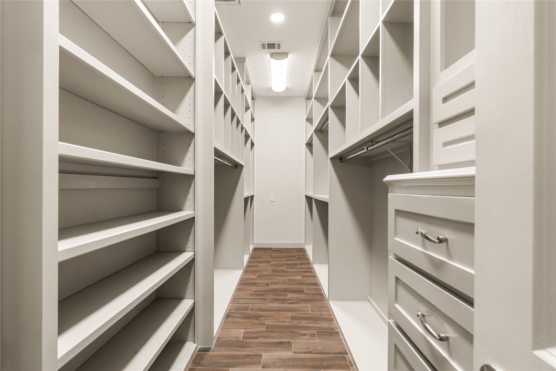 4719 Breezy Point Drive, Houston, TX 77345 Exceptional walk-in closet with extensive custom built-ins, shelving, hanging space, and drawers for beautifully organized storage