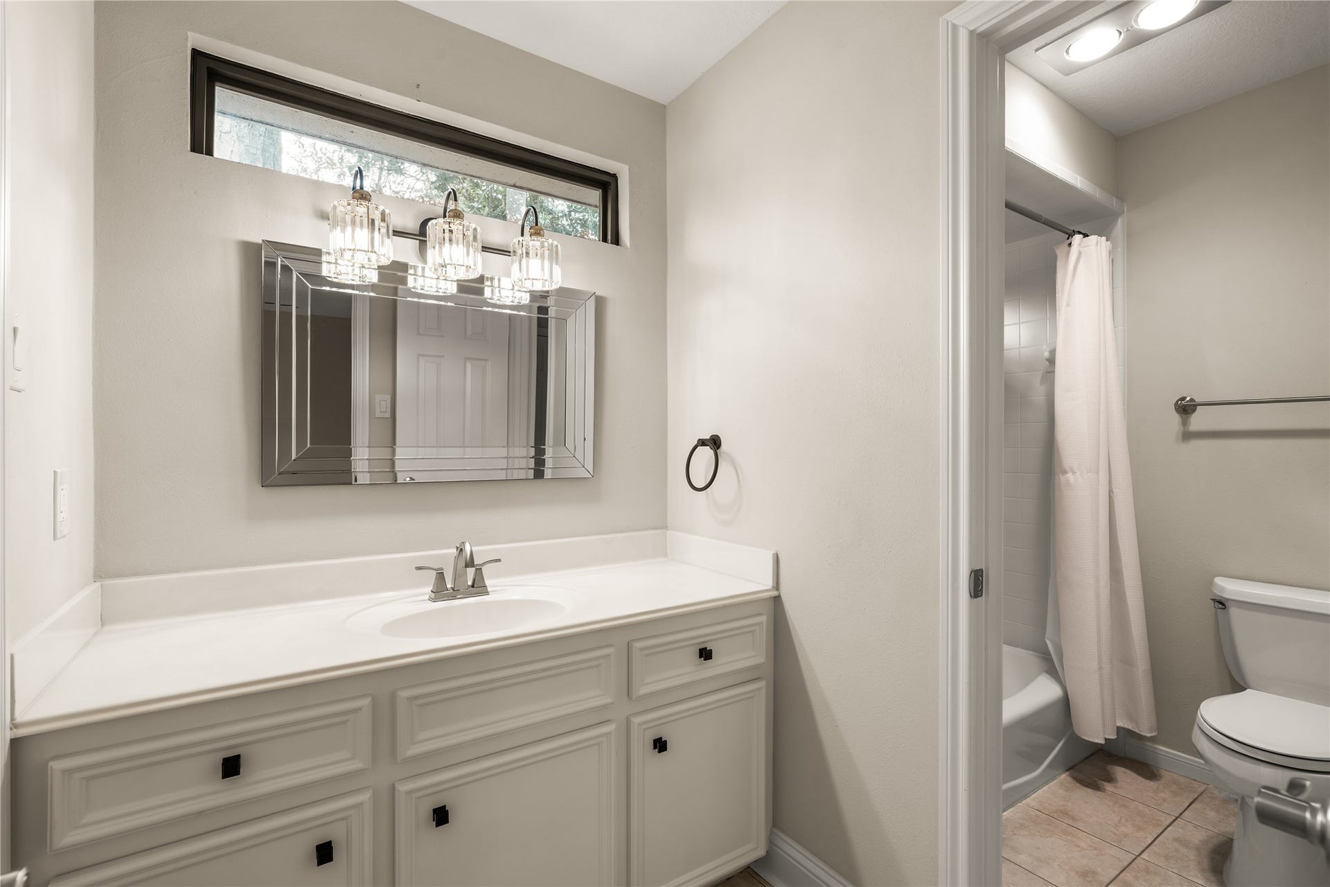 4719 Breezy Point Drive, Houston, TX 77345 Another secondary bathroom with a polished vanity area, offering generous counter space, ample cabinetry, and an elegant statement mirror, creating a refined and functional space for daily routines.