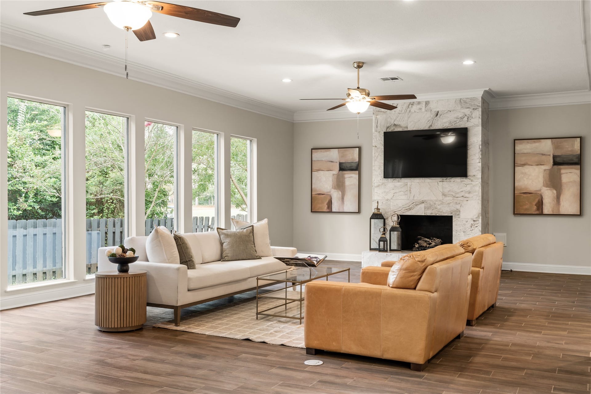 4719 Breezy Point Drive, Houston, TX 77345 The marble-clad fireplace creates a sophisticated focal point, complemented by a dramatic wall of windows and beautifully curated living spaces.