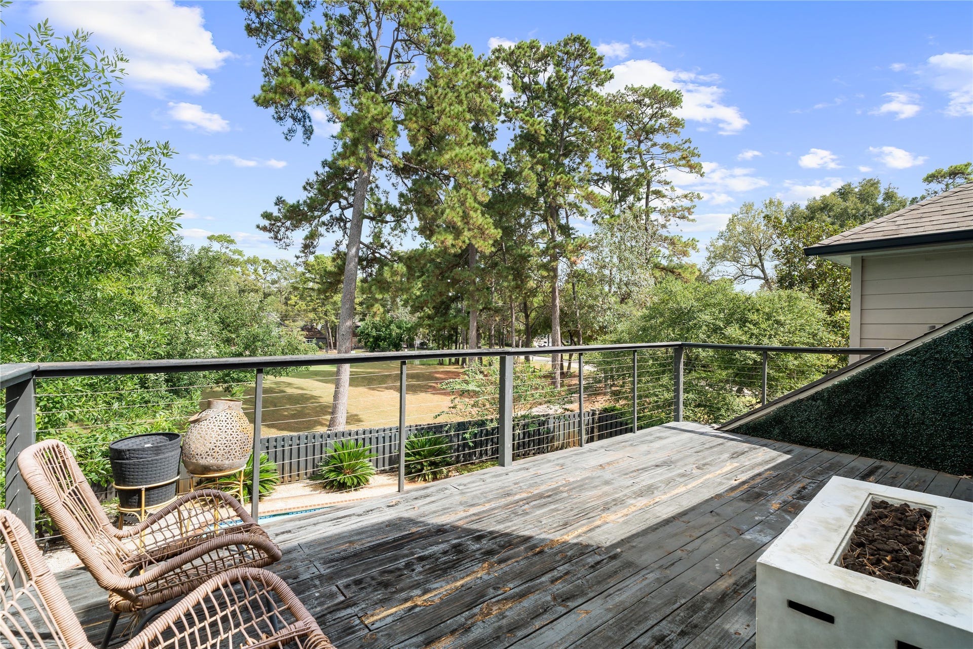 4719 Breezy Point Drive, Houston, TX 77345 An expansive elevated terrace creates an exceptional outdoor escape surrounded by mature trees, with plenty of room for lounge seating around the fireplace, entertaining, and enjoying the peaceful views.