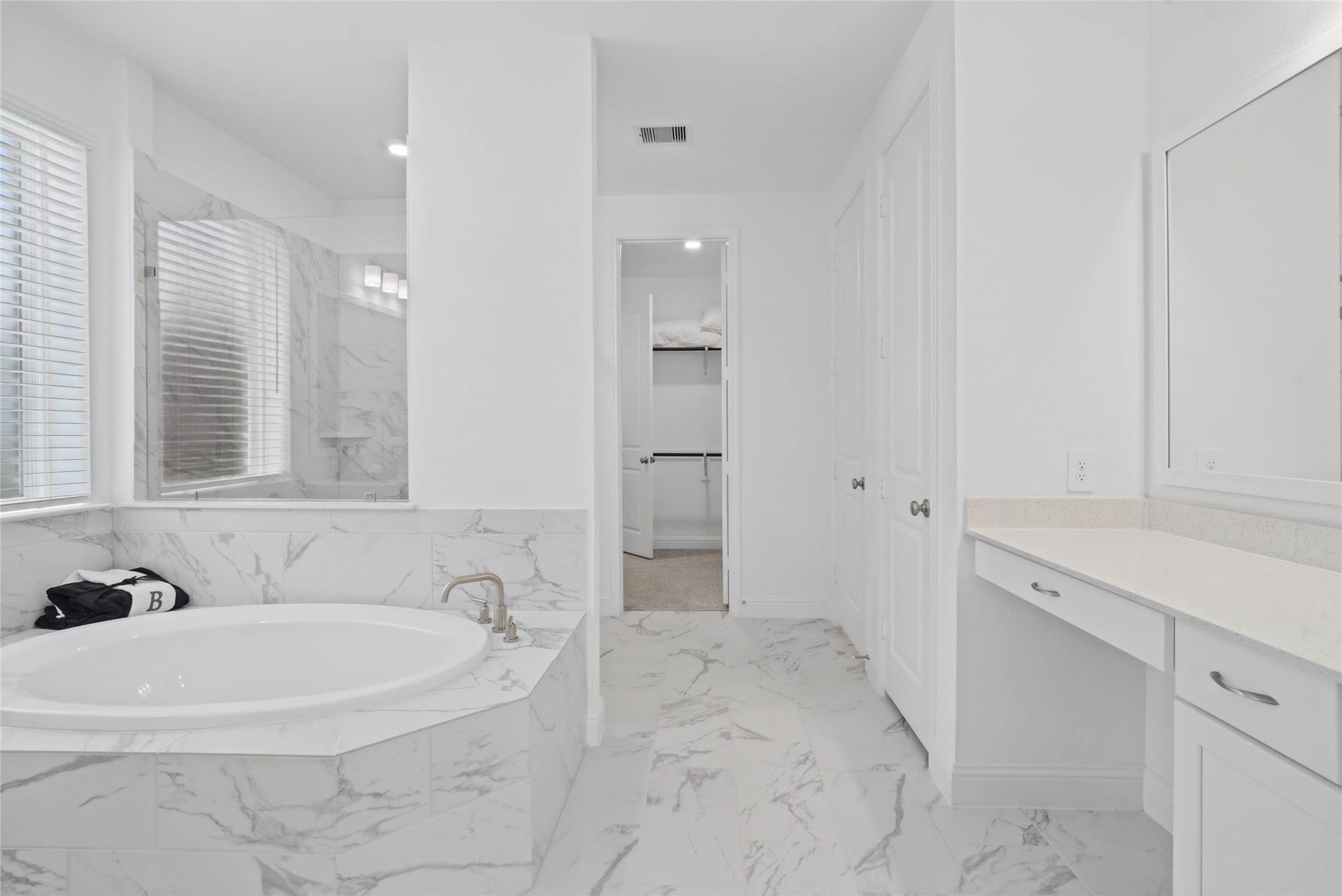 Modern primary bath features dual vanities with sleek cabinetry, quartz countertop, and crisp brushed nickel fixtures for a truly contemporary feel.