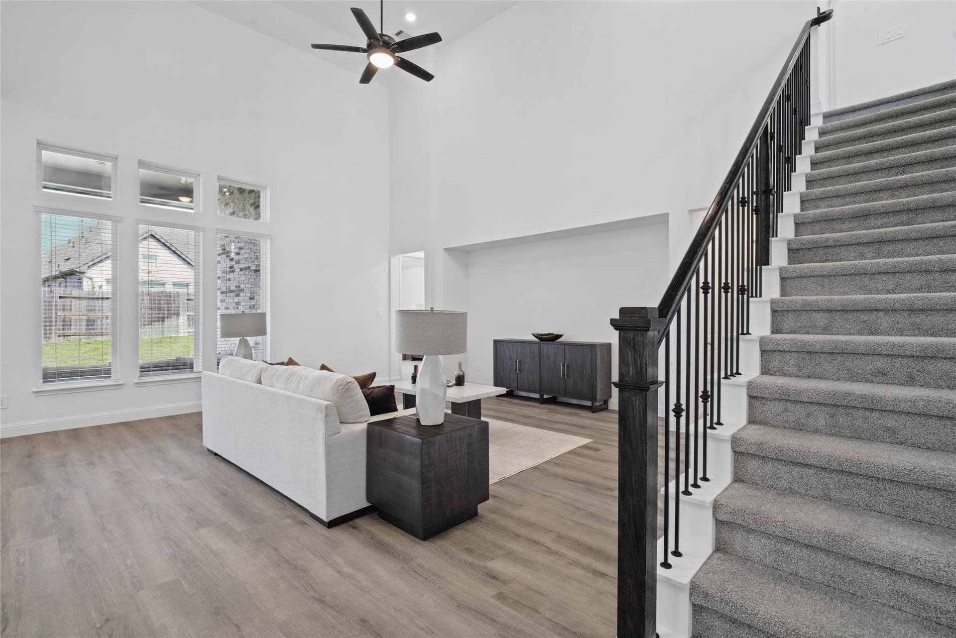 Focus on the quality architectural details of this home, including sleek wrought iron balusters and dark wood handrails.