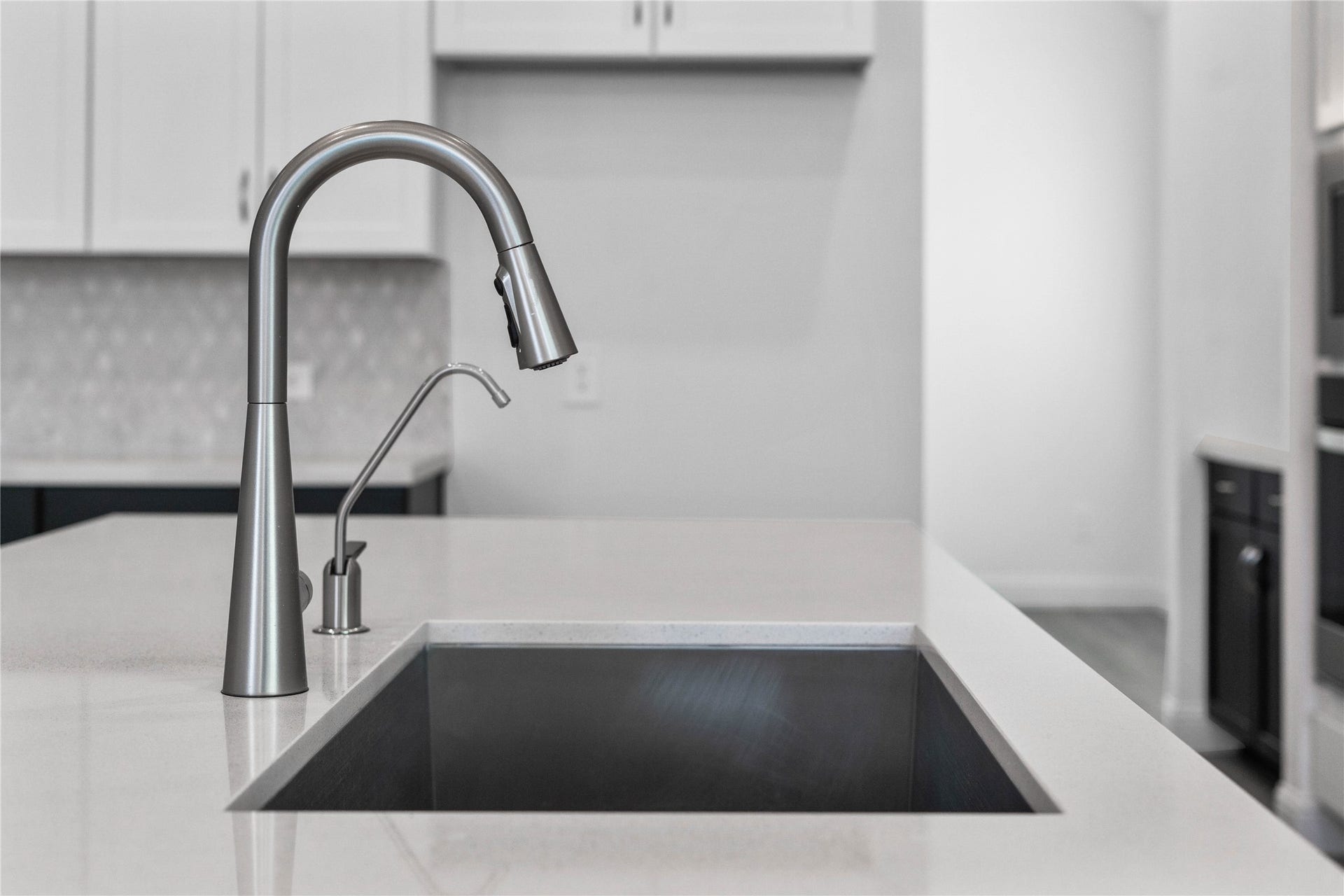 Moen Sleek Stainless Steel faucet offers versatility and contemporary design, complemented by a convenient separate filtered water dispenser faucet.