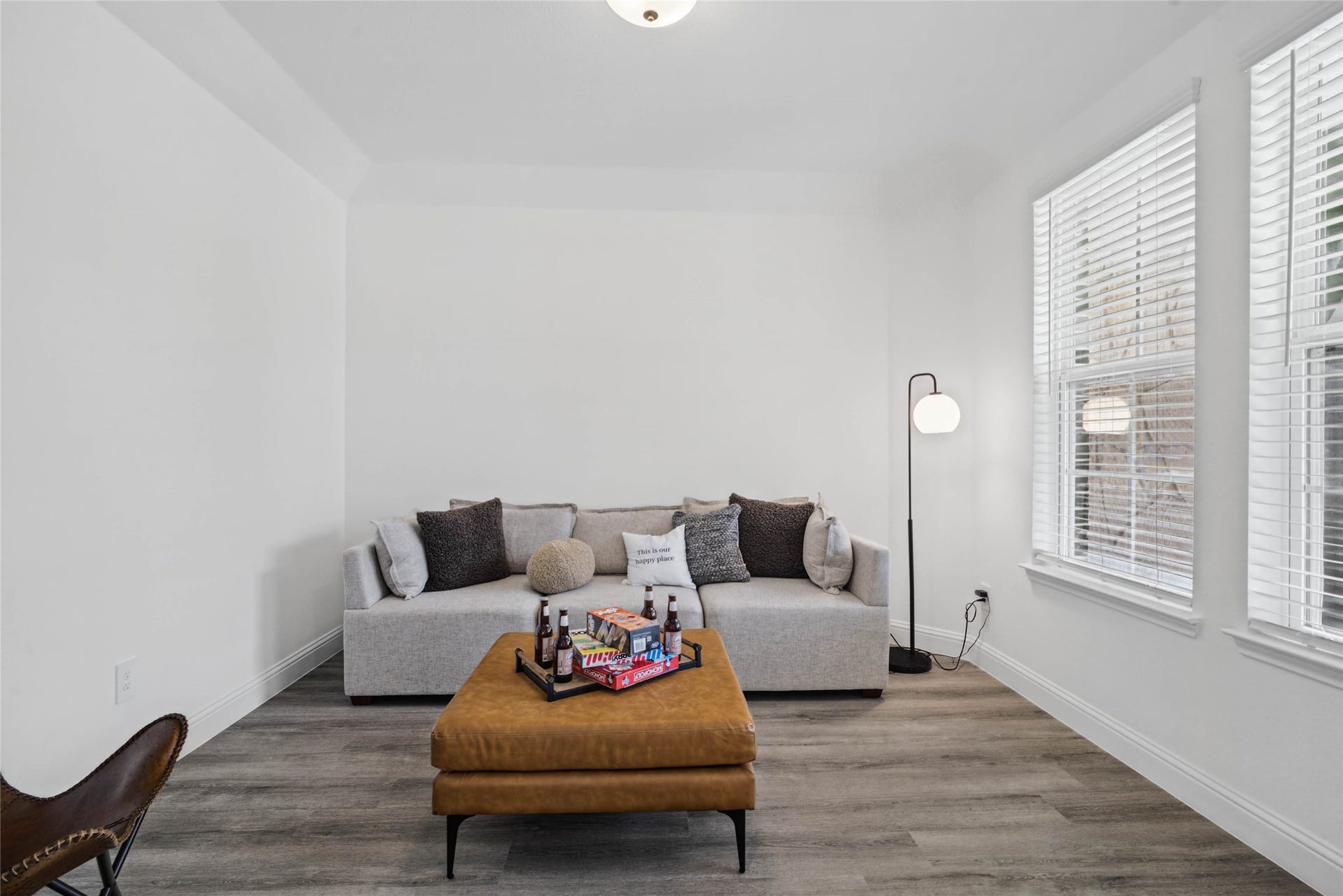 This handsome study  features luxury vinyl plank flooring, large windows with fitted blinds, high ceilings, lighting, and custom paint!