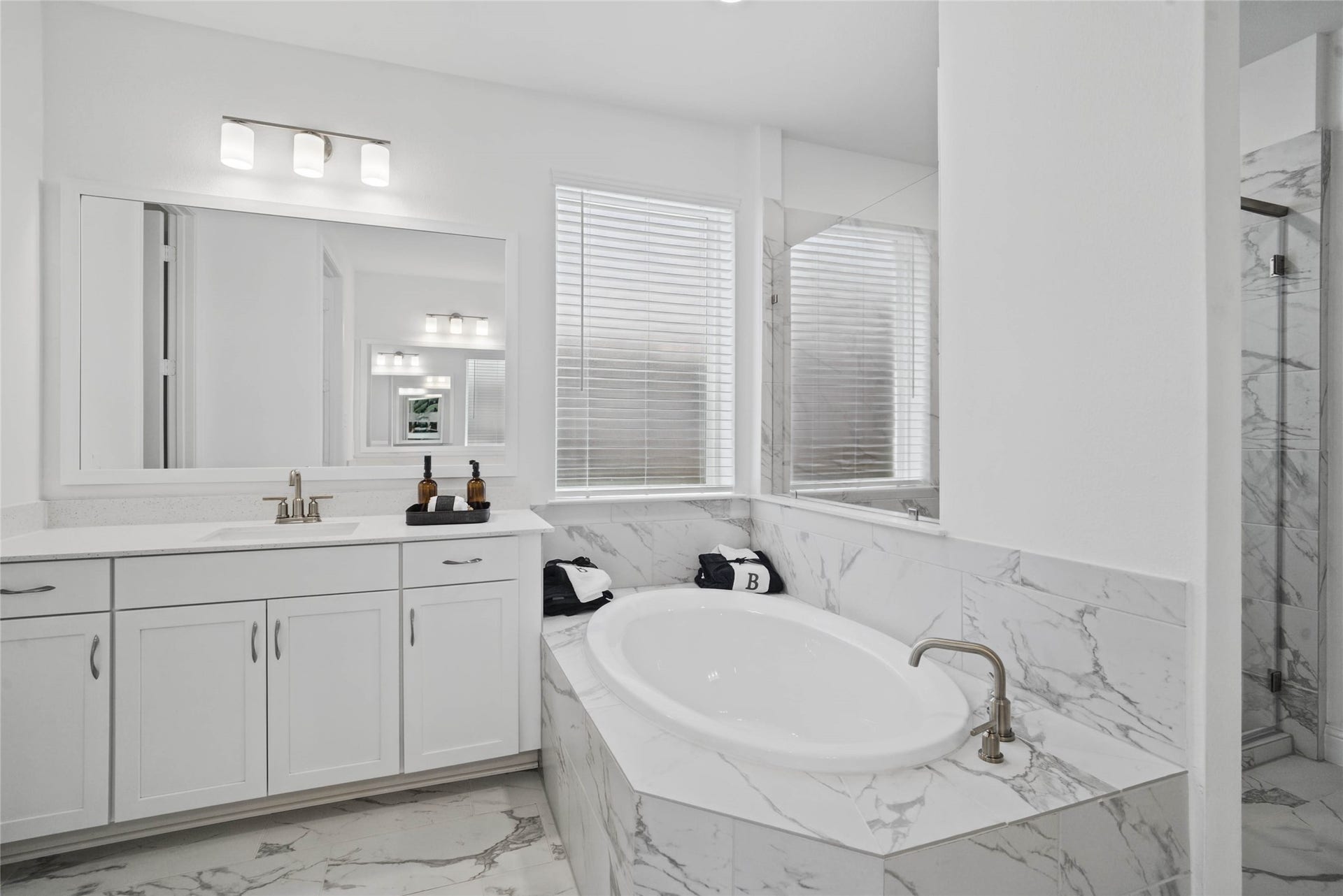 The centerpiece of this contemporary primary bath is the deep, freestanding bathtub, offering an ideal spot for relaxation with a unique view into the walk-in shower.